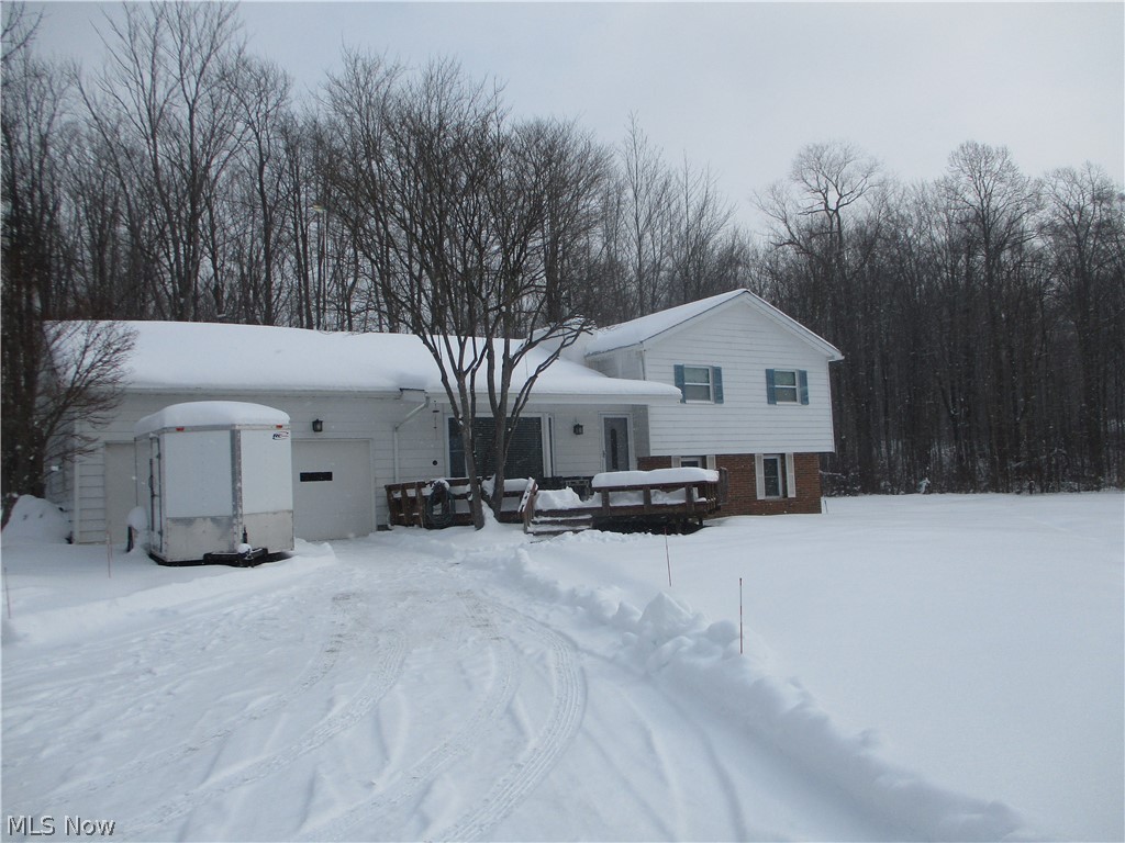 View this approximate 4 acre well maintained split with pond in front and treed backyard. A bay window and wood-burning fireplace accent the living room.   The kitchen features beautiful kitchen cupboards and an island with sink and eating area.  All appliances stay.  Home has replacement windows. The septic is approximately 3 years old.  The second full bath is not finished.  Furnace needs replacement. The lower level was partially waterproofed.  This property is priced to sell "as is".