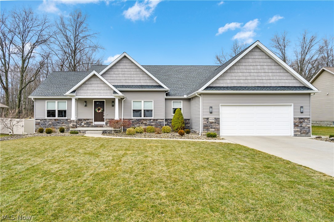 Built in 2013 by Meander Homes and occupied only by the original owner, this well-maintained ranch offers a thoughtful layout and beautiful setting. The exterior features excellent curb appeal with vinyl siding, stone veneer accents, decorative shake-style gables, and a covered front entry. Manicured landscaping and neutral tones give the home a clean, polished look.
Inside, vaulted ceilings and an open layout create a bright, spacious feel. The great room features hardwood flooring and flows naturally into the kitchen and dining area. The kitchen offers stainless steel appliances, tile flooring, ample cabinetry, and a large peninsula with seating and plenty of prep space. Toward the back of the home is a standout living space with vaulted ceilings, large windows, and a fireplace that creates a warm focal point while overlooking the backyard. Just beyond that area is another bright living space with a wall of windows and access outside. This flexible space could serve as a family room, sitting area, office, or playroom. The primary suite includes a large bedroom, walk-in closet, and an expansive private bathroom with double vanity, soaking tub, and separate shower. Two additional bedrooms are connected by a convenient Jack and Jill bathroom. The full basement provides excellent storage and future potential, including plumbing already roughed in for a bathroom if additional finished space is desired. Out back, the yard backs to mature trees, creating a quiet and private setting. You won't want to miss this one!