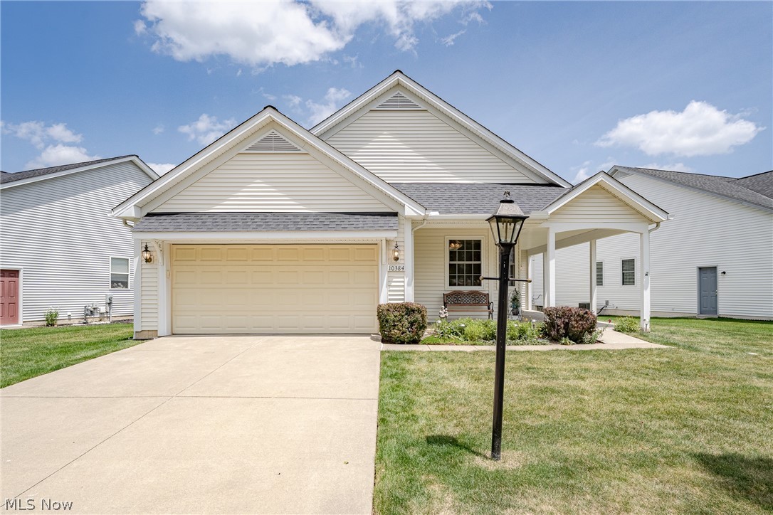 Country club living for the active adult awaits in this desirable gated community! Thoughtfully designed and meticulously maintained, this charming ranch offers an open floor plan with 9-foot ceilings and energy-efficient Stanek windows throughout. The bright, open-concept living room features a custom gas fireplace and flows seamlessly into the dining area, while large windows fill the home with natural light. The spacious kitchen offers a full complement of appliances, a breakfast counter, pantry, 42-inch cabinetry, and generous counter space for meal preparation. The bayed eat-in dinette provides the perfect spot to enjoy your morning coffee. The primary suite features two closets, including a walk-in closet, and a private bath with a walk-in shower. A second bedroom and full bath provide comfortable accommodations for guests or a home office. A convenient laundry/mudroom with cabinetry, shelving, and a utility sink completes the interior. Step outside to a raised wood deck with a SunSetter retractable awning, ideal for relaxing or entertaining, overlooking a private backyard lined with mature evergreen trees. Additional highlights include an attached garage with a 4-foot extension, 4-foot extensions to the kitchen and front wraparound porch, 30-inch doorways for enhanced accessibility, a newer roof, sprinkler system, 2023 refrigerator, and the convenience of one-floor living with no basement. Residents enjoy exceptional community amenities, including a beautiful clubhouse with party, meeting, library, billiards, and craft rooms, a full kitchen, swimming pool, tennis and pickleball courts, bocce ball court, and an exercise room. Enjoy the ease of low-maintenance living and feel like you're on vacation all year long!