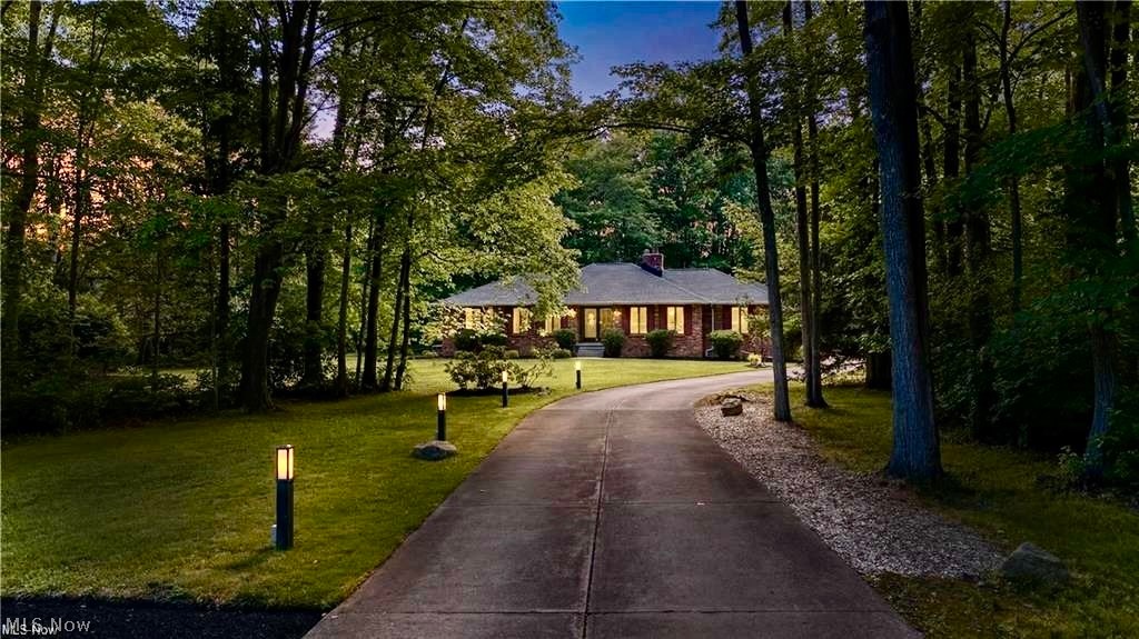 Living on the Fringe — Borrow the View, Skip the Rules. Some homes simply stop you in your tracks. This stunning ranch on 1.80 acres, offers 4,000+ sq ft of total living space w/mid-century modern soul, is one of them. Set against mature trees & rolling greenery just off the fairway, w/ Chagrin Valley CC as a scenic neighbor, it commands attention from the moment you arrive. A long, private driveway winding gracefully thru beautifully landscaped grounds, comfortably accommodating up to 15+ cars for elegant entertaining. As you enter, the soaring cathedral great rm dazzles w/a dramatic wall of windows, skylights, & slider, flooding the space w/nat light. A rare touch of luxury: an indoor grill just off the great rm gives joy to those who love grilling year-round. The eat-in kitchen w/breakfast bar, SS appls, pantry,  formal dining rm, & living rm offer gracious spaces for everyday living, flowing easily into the lounge, where a striking stone frplc & wet bar create a warm, sociable gathering space on those cool evenings. Walk out to a private, wooded oasis w/extended multi-level decks & paver patio overlooking the stunning private lush landscaping & the fairways visible further out, a picture-perfect backdrop for sophisticated summer evenings. This home offers gleaming wd flrs, 4 bdrms & 3.5 baths, a primary suite w/it’s own private deck & spacious walk-in closet & steam shower. Attached 3-car garage adds everyday ease. The fully remodeled (‘26) Lower level offers new carpeting, fresh paint, full bath, & wet bar. Major systems thoughtfully updated, incl. roof ('25), garden windows/slider ('26), HVAC, & H2O.+much more. Ideally positioned near top-rated Orange Schools, Trader Joe's, Whole Foods, Eton, boutique shopping, & easy access to 271/422—refined living in one of the area's most coveted settings of Moreland Hills. Full list of updates in supplements. View 3D tour. Call for a private tour.