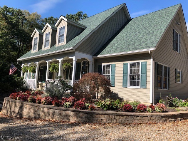 This spectacular home is paradise in the country!  Sundrenched rooms galore. Fireplaced great room leads to the concrete patio with view of enchanting waterfall and pond.Fully applianced eat-in kitchen with granite and Merillat maple cabinets. All low maintenance wood floors are Hickory wood and recently refinished. First floor master ensuite offers new carpet, granite countertops, new skylight and ceramic floors. The second full bath on the first level also offers granite countertops and ceramic flooring. Enjoy the morning sun on the enticing full front porch overlooking woods. When you visit the walkout lower level, you will notice poured concrete walls, workshop area, and lots of storage space as well as steps for private entrance from oversized 2 car, attached garage. The exterior of the home has teak flower beds with lots of perennials, oregano, thyme, sage, chamomile, and tarragon. Enjoy long walks in the acres of woods. The additional 30X40, two story garage with electric was bu