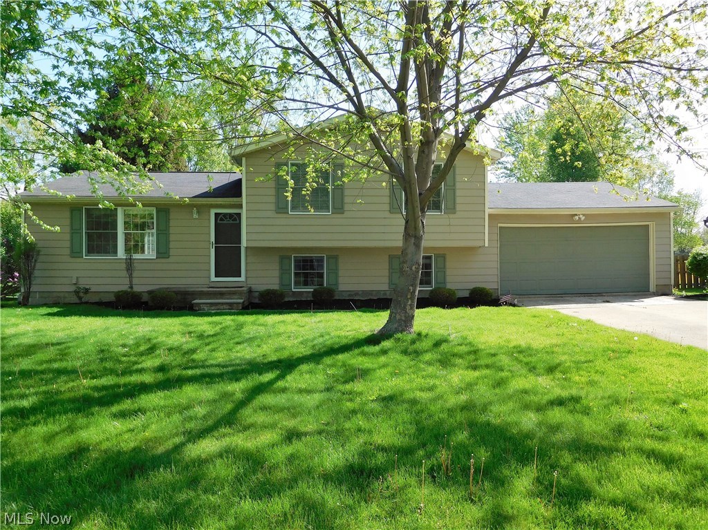 Fabulous split level home just minutes from shopping, parks and restaurants. Spacious living room with newer laminate flooring and large picture window.  Dining area with sliding glass door that leads to concrete patio and backyard.  The kitchen is AWESOME, plenty of cabinets, newer counter-top, sink and ALL stainless steel appliances remain with the property.  First floor has open concept feel.  Upstairs is huge master bedroom and two other good sized rooms.  Full bathroom has been updated.  Downstairs is large family room with fireplace and newer 1/2 bath plus a mud room area that leads to the two car attached garage.  Laundry is in basement also--washer and dryer remain too!  Home warranty included for added peace of mind!  Furnace replaced (2009), water tank (2014), air conditioner (2009), sump pump (2016).  All decor is light gray with white trim--very modern.  Nothing to do but move in and enjoy this gorgeous home!