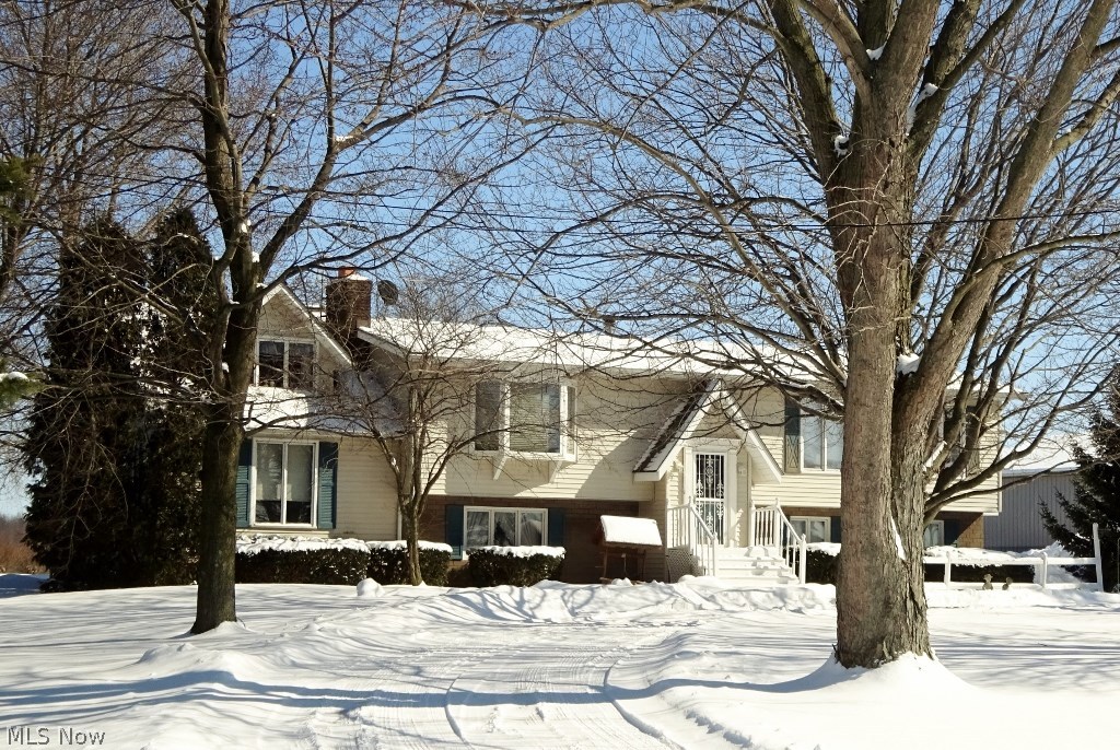 Custom Built Bi-level set on 1.5 acres in Suffield.  3 possible 4 bedrooms, 3 full bathrooms.  Whether you like to entertain or just relax – you will love this home.  Huge living room, formal dining room. Corian Counters and Tile Floor in Kitchen.  Master bedroom is expansive – with sitting area and room for a King sized bed + Imagine an 11x11 Walk-In Closet.  Enjoy an office/library with built in bookshelves.  Open Family room with Wood burning fireplace and has a Rear Foyer (10x8) to make easy access to the lower patio & backyard.  Think Spring - Sunlight fills the 3 season room - Vaulted ceiling.  Perfect room to enjoy morning coffee & plan your day.  Concrete Driveway.  Attached garage & Detached 24 x 30 - 24 x 32 pole building for all your toys.  Great location with easy access to Akron, Canton or Kent.