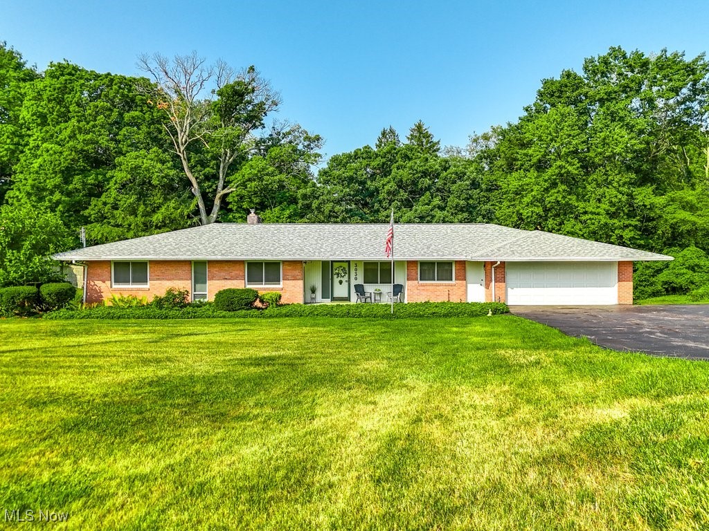 Seize the opportunity to own this beautifully preserved mid-century modern home, crafted by its original owner/builder. Step onto the charming front patio, and enter through the large custom front door. This home features stunning refinished hardwood floors throughout and 2 wood-burning fireplaces to cozy up to. The great room is perfect for entertaining and it’s only a few feet short of a bowling alley”. The floor-to-ceiling windows provide gorgeous views of the private wooded lot and fill the room with natural light. From the great room you can access the custom screened-in patio with access to the outdoors.  The first floor offers an eat-in kitchen with an original built-in Frigidaire oven and 3 spacious bedrooms (1 w/ a half bath). The large full bathroom features a built in double-sink vanity, and new shower and toilet. The Walkout Basement increases the usable space x2 and could be used like an apartment! Highlights include a 4th bedroom, bathroom,  kitchen area,  fireplace, washer/dryer hookup, and large workshop. Recent updates include a New Roof 2022, New Garage Door & opener 2023, New Water Softener 2024, Septic Cleaning 2023, New toilets. New screens available for the new owner. Enjoy the added amenities - Washer/Dryer, Pool Table, Ping Pong Table, and riding mower (all included). Don't forget to check out the storage room adjacent to the walkout basement. For buyer's peace of mind, the sellers are offering a 1 year home warranty. Estate is being Sold As-is.