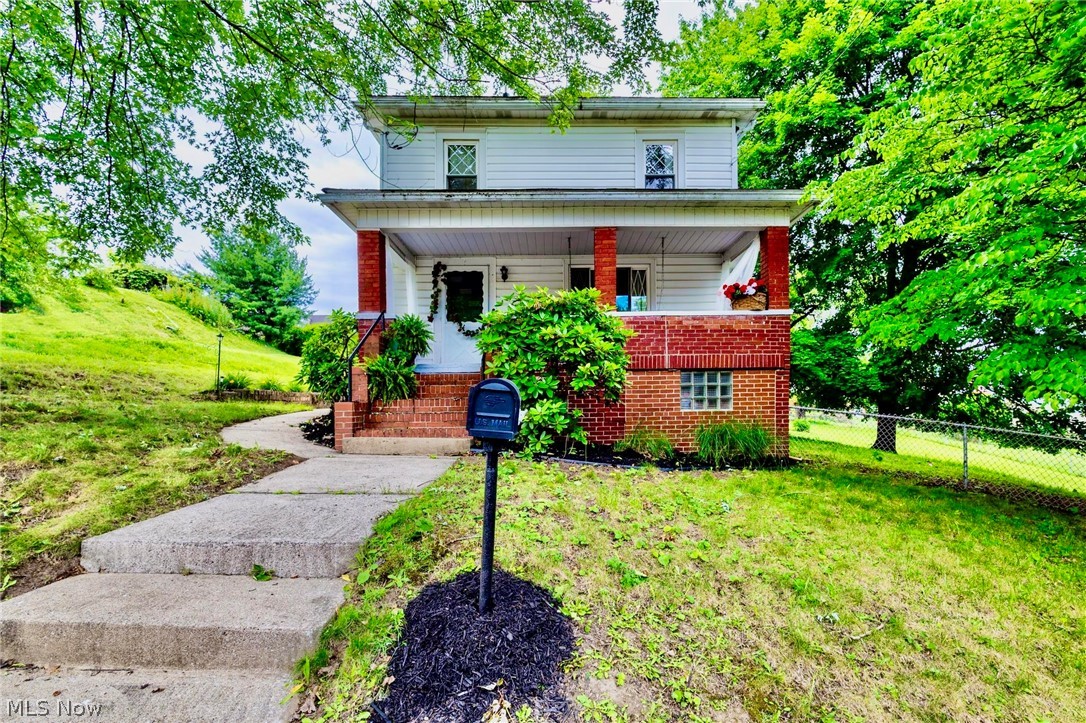 WELCOME HOME! This Weirton Heights residence (3 BR/2 BA)  offers City conveniences while you can also enjoy the peaceful retreat.  Situated on almost half an acre, this property offers a beautiful park-like setting you'll enjoy year-round. The partially fenced backyard provides plenty of space for pets, play, gardening, or outdoor entertaining. Parking is a breeze with the potential of a convenient drive-through parking area extending from the street to the rear alley, providing ample room for multiple vehicles, guests, or recreational equipment.  Inside, you'll appreciate the home's character with original built-ins throughout, adding both charm and functionality. The cozy living area features an electric fireplace with an attractive mantel, creating the perfect spot to relax and unwind. Perfect for hosting gatherings, the formal dining room features a convenient pass-through window to the kitchen, making serving meals and entertaining effortless. Just steps from the kitchen, covered patio access extends your living space outdoors, creating the ideal setup for cookouts, dining al fresco, and enjoying time with family and friends. Durable laminate flooring flows throughout the main level, offering easy maintenance and a modern touch. Call today!