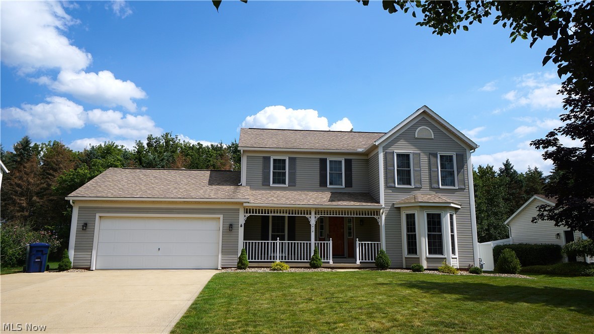 Welcome home to this warm and inviting 3-bedroom, 2.5-bath Colonial in the desirable Tallmadge Hills neighborhood! Offering 2,080 sq. ft. of comfortable living space, this home blends farmhouse charm with thoughtful updates and an unbeatable location close to schools, shopping, and quick highway access. Relax with your morning coffee on the expansive covered front porch before stepping inside to warm laminate wood flooring that flows through much of the main level. The spacious living room is filled with natural light from a stunning floor-to-ceiling bay window, while the cozy family room features plush carpet and a beautifully updated gas log fireplace with stone and wood accents. The eat-in kitchen is perfect for everyday living with granite countertops, tile backsplash, a stainless steel undermount sink beneath a bright bay window, peninsula with breakfast bar, and newer appliances. A formal dining room is ready for holiday gatherings, and the convenient first-floor laundry makes daily chores a breeze. Just off the dinette, through a sliding glass door, the multi-sided three-season room features vaulted ceilings and skylights for year-round enjoyment. Outside, the low-maintenance Trex composite deck offers the perfect place to relax or entertain. Upstairs, the oversized primary suite includes a walk-in closet and private en suite bath. Two additional bedrooms and another full bath complete the second floor. The partially finished lower level provides a recreation area with durable epoxy flooring and wiring already in place for a media room. The extra-deep two-car garage includes a 13x9 rear extension, offering excellent storage or workshop space. Additional updates include LG washer and dryer (2022), gas log fireplace makeover (2022), double-pane windows (2018), high-efficiency furnace, central A/C, and AprilAire humidifier (2016), plus a dimensional shingle roof (2011). This well-maintained home is move-in ready for its next owners—schedule your showing today!