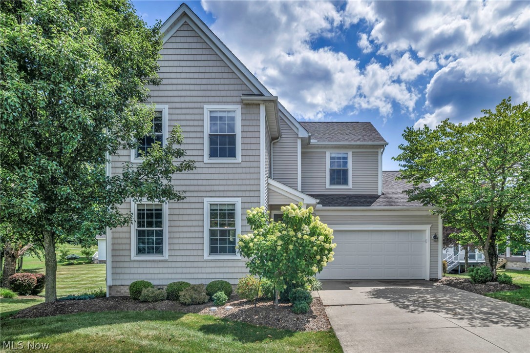 Welcome home to this beautifully maintained 4-bedroom, 2.5-bath Colonial with a finished walk-out lower level in the sought after MacIntosh Farms community. The inviting main level offers a spacious living room with hardwood floors, cozy fireplace, and ceiling fan that flows into the dining area and eat-in kitchen. The kitchen features granite countertops, a breakfast bar, stainless steel appliances (2018), abundant white cabinetry, travertine flooring, recessed lighting, and updated fixtures. Recessed lighting continues into the main floor hallway and upstairs, creating a bright, welcoming feel. Upstairs you'll find 4 generously sized bedrooms and two full baths, including a spacious primary suite with hardwood floors, a walk-in closet, and private bath. The remodeled upper bath includes a new vanity and flooring(2022), while ceiling fans(2018) and updated fixtures add comfort throughout. The finished walk-out lower level provides a large recreation room, laundry area, and ample storage. Step outside to the expansive 20'x20' deck with updated with maintenance-free PVC railings and new steps (2019), plus the deck and trim professionally painted(2025). The lower-level patio features a French drain for proper drainage and a concrete walkway to the garage(2020). Professional landscaping(2018) enhances the home's curb appeal. Enjoy maintenance-free living with outstanding MacIntosh Farms amenities, including a community clubhouse, swimming pools, tennis courts, fitness center, walking trails, playground, and scenic green space. Conveniently located just minutes from downtown Cleveland and Akron, Metroparks, bike trails, shopping, dining, golf, and recreation. Move right in and enjoy!