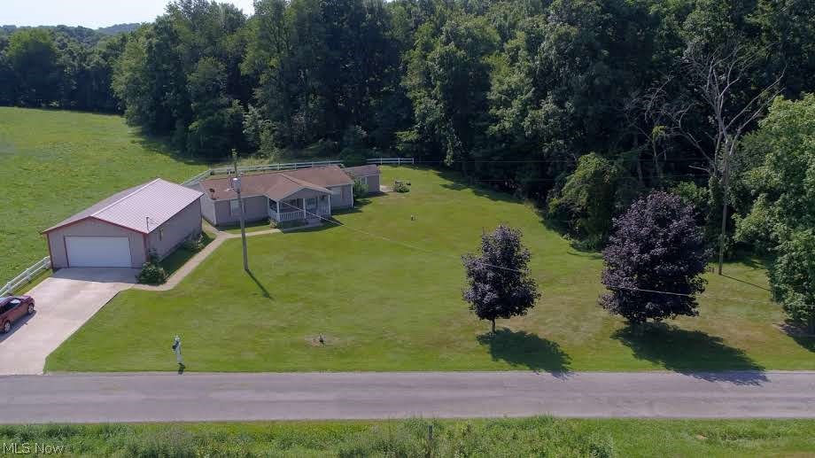 About 10 minutes from town, you will find this country property surrounded by farm fields and a little woods. Concrete drive to oversized 2 car garage/shop (24X40) and it is wired for 220 amp.  Sidewalk wraps to front porch or to back deck.  The front porch is a perfect place to enjoy morning coffee or unwind in the evening.  Living room with picture window.  Dining room with patio door that leads to back deck.  Open kitchen with all appliances staying.  Tons of cupboards space.  First Floor laundry with the back door leading to smaller deck.  The owners retreat featuring huge walk in closet and split bathroom layout.  2 bedrooms and full bathroom complete the inside of this wonderful home.  Walkup cellar and the rest of the home is on a crawl space.  Partially fenced in yard.  Part of the woods are also on this 1-acre lot.  Shed on property as well. AC, Water Tank, Well Pump & All Appliances: 3 years old.  Septic was last pumped in 2021.  This place is practically begging for you to make it your new haven!