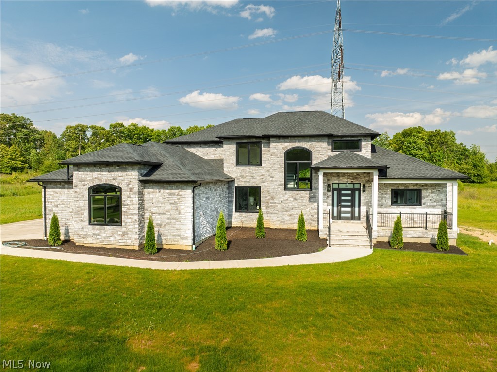 Luxury meets modern design in this exceptional new construction home in sought-after Grandview Farms. Offering 5 bedrooms, 4.5 baths, and an open-concept floor plan, this stunning residence showcases impeccable craftsmanship and high-end finishes throughout. The main level features beautiful hardwood floors, soaring spaces filled with natural light, and a dramatic slate fireplace wall framed by custom wood build-ins next to an expansive wall of windows. The chef's kitchen is designed to impress with a striking quartz island and backsplash, custom cabinetry, and a walk-in pantry complete with custom shelving, quartz countertops, and a full-size refrigerator. The first-floor primary suite is a true retreat, featuring a spa-inspired bath with heated marble floors, a soaking tub, waterfall shower, double custom vanity, and a large custom-built walk-in closet with separate his-and-hers sections. A thoughtfully designed first-floor laundry room with custom built-ins adds everyday convenience. You'll also find a thoughtfully designed large first floor office.  Upstairs, you'll find three spacious bedrooms, each with walk-in closets, along with two full baths with custom vanities. The mostly finished lower level expands the living space with an additional bedroom, full bath, abundant storage, and endless possibilities for entertaining, recreation, or multigenerational living. Completing this extraordinary home is a three-car garage pre-wired for electric vehicles, with direct access to the basement. Located in one of the area's most desirable communities, this remarkable Grandview Farms residence offers the perfect blend of luxury, comfort, and modern functionality.