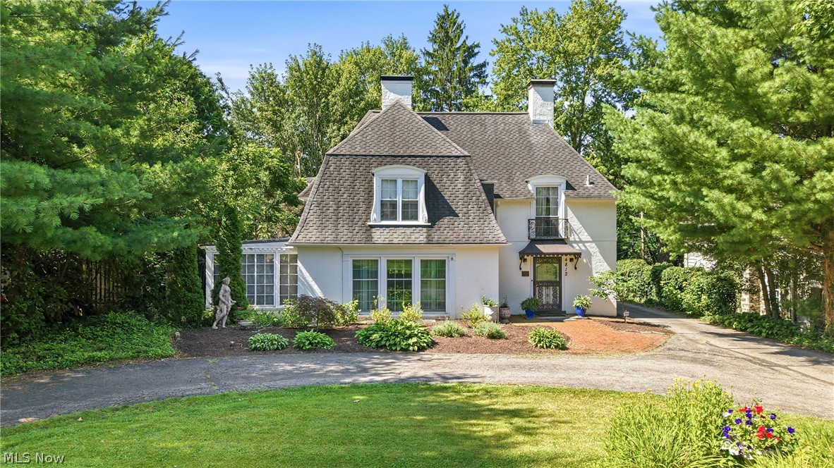 Step into a truly spectacular French Country inspired home in the coveted Forest Glen Estates historic district of Boardman, Ohio. Designed in 1929 by the renowned Cleveland architectural firm Copper & Dunn, this one-of-a-kind custom designed residence showcases timeless craftsmanship and enduring character throughout. Offering over 2,100 square feet of beautifully appointed living space, the home features three generous bedrooms, two full baths, and two half baths. Rich hardwood floors, original plaster walls with elegant moldings, and a striking wrought iron staircase create an atmosphere of classic sophistication. The entire main floor is graced by large newer windows that bathe the rooms with sunlight. The formal living room centers around a cozy gas fireplace, while the expansive family room addition features a cathedral ceiling, skylights, custom bar and leads to the gorgeous private courtyard. The first floor also features a formal dining room, light filled breakfast room, wood paneled office, convenient half bath and sitting room with french doors. The centrally located kitchen offers stainless appliances and granite counters. Upstairs the primary suite is a true retreat, complete with its own gas fireplace and private en suite half bath. Two additional spacious bedrooms, a full bath and many closets and built-ins complete the second floor. The semi-finished basement offers a full bathroom, comfortable flex space, dedicated laundry area and abundant storage. Outside, the detached oversized two car garage, mature corner lot with a small township managed park directly in front of the yard establish a setting that enhances the home’s exceptional curb appeal. Rarely does a home of this architectural significance become available. Meticulously preserved and thoughtfully maintained, this Historic Forest Glen gem offers the opportunity to own a distinctive residence where historic elegance, quality craftsmanship, and everyday livability come together beautifully.