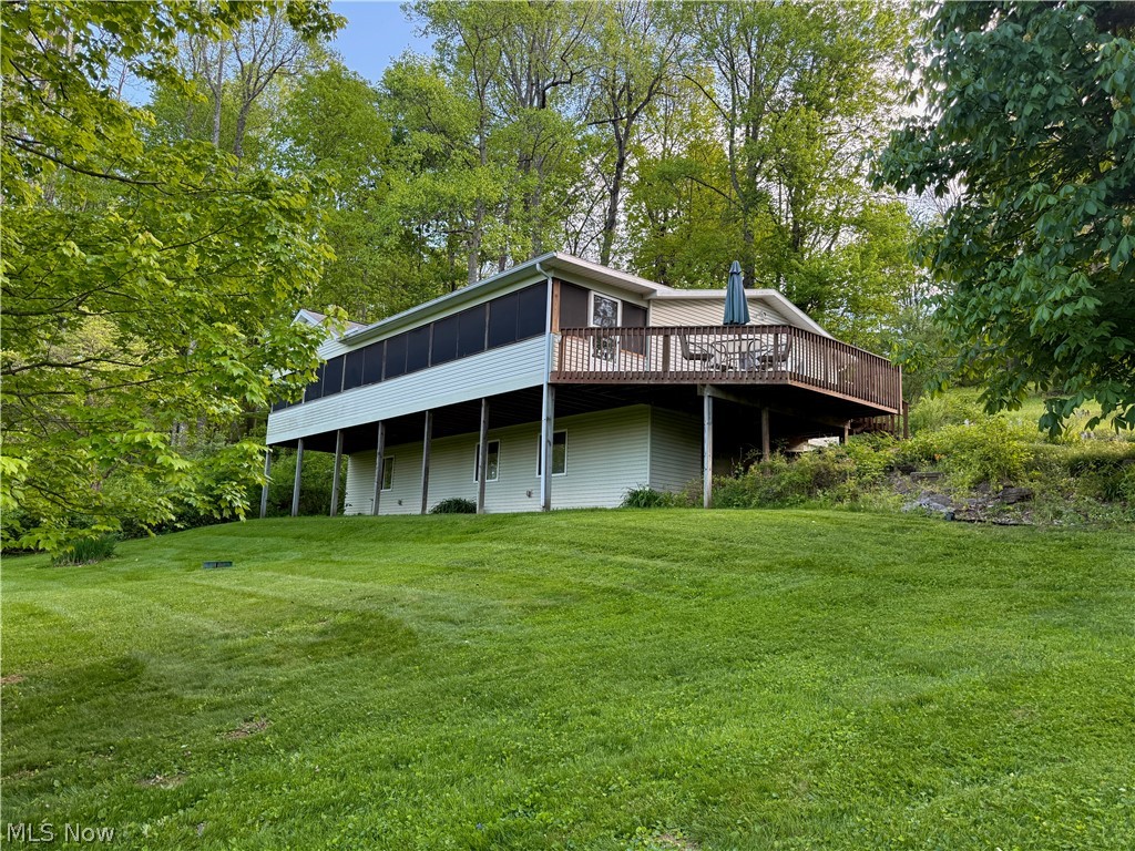 Welcome to your private retreat in the gated community of Lake Buckhorn, offering lake access, recreation, and peaceful wooded surroundings. Situated on approximately one acre across three lots, this beautifully updated home features an open floor plan with a spacious kitchen, dining, and living area centered around a cozy wood-burning fireplace. The main-floor owner’s suite includes a full bath and a private laundry. A bonus room, counted as a 5th bedroom on the auditor’s card, offers flexibility as a family room, office, or guest space with sliding glass doors leading to a patio and freestanding firepit. Enjoy the full-length screened porch with ceiling fans overlooking the wooded property. The lower level includes 3 large bedrooms, a full bath, laundry, and utility/storage room. Three-car garage plus storage building. Association and membership fees apply - contact LBPOA directly for details.