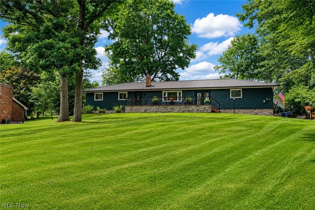 Tucked away on a half-acre in a quiet cul-de-sac lot surrounded by trees, this ranch offers attractive major updates, comfortable one-floor living, inviting indoor-outdoor spaces! A concrete walkway leads to the enlarged front porch and into an enclosed breezeway with a warm wood ceiling. Inside, the living room features new flooring, updated lighting, a wood-burning fireplace with recently replaced components, and an open flow into the main living spaces. The enormous eat-in kitchen is the heart of the home, offering a new double oven with hood, stainless steel appliances, an island, additional breakfast bar, and a bright dinette area with ceiling fan, bay windows, and a built-in bench seat.
Just off the kitchen, a stylish half bath with ceramic tile brick-look flooring and shiplap detail connects through a pocket door to the full main bath with a tile tub/shower combination. Three bedrooms are located on the main level, including a spacious primary bedroom with double closets. The lower level adds great bonus space, a full bath, laundry area, storage, and water softener.
Outside, enjoy a covered walkout to the concrete patio, fully fenced backyard, gravel fire pit area, and plenty of room to relax or entertain. Additional highlights include a 2-car attached garage, metal roof, new flooring throughout, new lighting and electrical, windows/roof/gutters/glass block in 2019, HWT 2020, garage door 2020, breezeway doors 2023, exterior paint 2025, and septic pumped in 2025. A wonderful ranch with major updates, inviting indoor-outdoor living, and a great Green location!