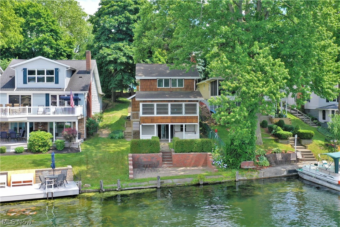 Welcome to this lake home that sits on the West Reservoir of Portage Lakes! This home boasts stunning views of the lake throughout and is a short boat ride away from the restaurants on the lake! A living room with a beautiful fireplace that opens to a stunning three season room. This three season room is the perfect spot to sit on these long summer days and watch the boats go by. Two nicely side bedrooms and one that includes an ensuite. A walk out basement that leads to steps down to a patio. This patio will be your entertaining spot all summer long!  With some TLC this house will become your perfect home, for lake life living!