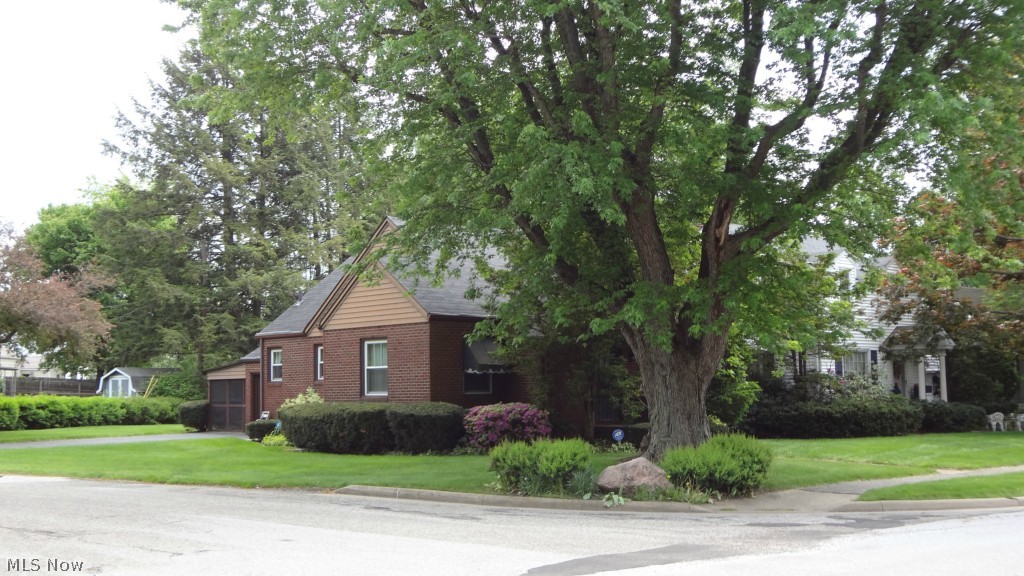Off the market for a short time to remove wallpaper, repaint, install new flooring in kitchen, install new glass block windows and more maintenance. Now ready for new buyers. Quality built 3 bedroom, 1.5 bath all brick bungalow is on a corner lot not far from Arrowhead Golf! Easy access to I-77. Warm wood paneling and nice built-ins in the large second downstairs bedroom that could be used as a den. Hardwood flooring under neutral carpeting in dining room and living room. The second floor bedroom is large enough for several beds and has a half bath that could easily be made into a full bath. There’s a knotty pine rec room rec room in the basement with a decorative fireplace. Recently replaced windows, refrigerator and garbage disposal. Washer and dryer included. Attached to the garage is a carport that becomes a screened patio when the screens are dropped down from the ceiling this spring. If that’s not enough, a one year home warranty is included.