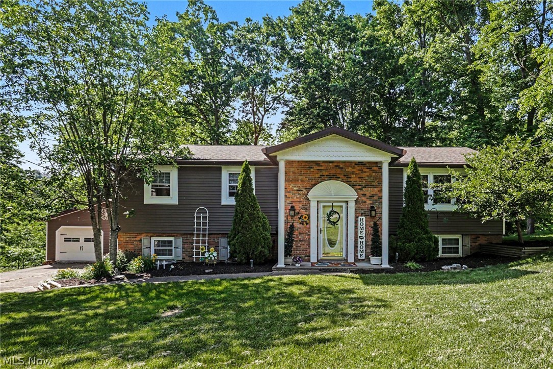 Lovingly maintained by the same family for nearly four decades, this well-cared-for 3-bedroom, 2.5-bath home is ready for its next chapter. Situated on two parcels totaling 2.74 wooded acres, the property offers a rare combination of privacy, mature trees, and room to roam while remaining convenient to everyday amenities and just a short drive to I-70. Inside, you'll find comfortable living spaces that have been thoughtfully updated and meticulously cared for over the years. Recent improvements include a newer roof, newer siding, newer carpet, updated kitchen appliances, and added insulation in the walls and ceilings to improve energy efficiency. The versatile floor plan includes a recently added main-floor laundry room that can also serve as a home office, playroom, or flex space, complete with abundant cabinetry and built-in hampers. The finished lower level provides valuable additional living space for a family room, recreation area, hobbies, or whatever best suits your needs. A screened porch overlooks the peaceful wooded setting, creating the perfect place to enjoy morning coffee, evening relaxation, and the beauty of every season. Outside, the property's natural character shines through with mature hardwood and nut trees, a beautiful flowering cherry tree, and plenty of room to explore across both parcels. The detached garage offers space for two vehicles plus a dedicated workshop area, while the additional lower-level garage bay is ideal for a classic car, restoration project, lawn equipment, or outdoor toys. Storage beneath the deck provides even more room for tools and seasonal items. Filled with character, memories, and decades of careful stewardship, this special property offers a unique opportunity to enjoy the space, privacy, and lifestyle that only a property like this can provide while creating memories of your own.