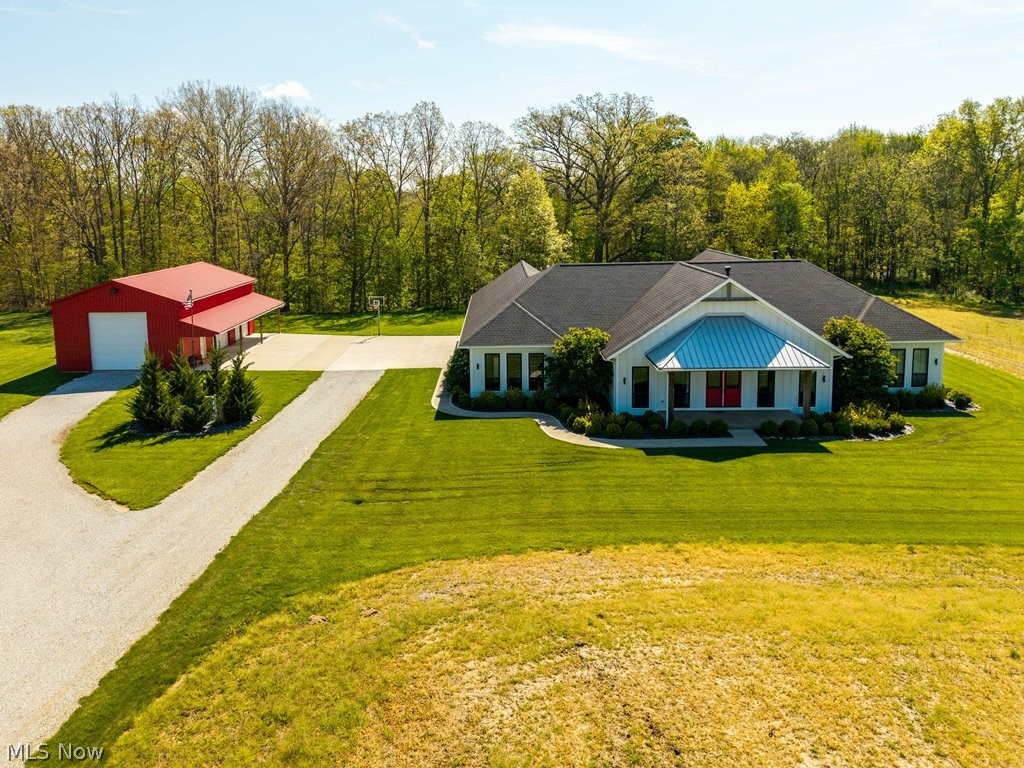 Tucked more than 700 feet from the road on over 14 secluded acres along the East Branch of the Black River, this extraordinary custom-built Modern Farmhouse estate is a masterclass in craftsmanship, scale, and lifestyle-driven design. Framed by mature trees, wooded surroundings, and riverfront scenery, the property offers exceptional privacy with potential for a future homesite or multigenerational living opportunity. 
Thoughtfully designed for elevated everyday living and seamless entertaining, the residence offers nearly 8,000 square feet under roof with an effortless connection between indoor and outdoor spaces. A dramatic zero-threshold multi-slide glass wall opens the main living area to an expansive covered terrace overlooking the resort-style outdoor setting featuring a 16x40 pool, outdoor kitchen, bar, covered lounge, and multiple gathering spaces. Inside, soaring vaulted ceilings clad in reclaimed wood, custom barn beam detailing, handcrafted doors, and wide-plank hardwood flooring create an atmosphere that is both refined and inviting. The chef’s kitchen is appointed with professional-grade Bertazzoni appliances, luxury cabinetry, granite surfaces, and designer tilework. The owner’s suite serves as a private retreat with a spa-inspired bath, zero-entry dual-head shower, oversized walk-in closets, coffee bar, private covered porch, and fireplace. The finished lower level features a 160” projection wall, full bar, guest bedroom, full bath, and extensive storage. 
Additional highlights include geothermal zoned climate control, Anderson low-E windows, HardiePlank siding, architectural roofing, professional landscaping, and a 30x50 barn with electric, concrete floors, and plumbing for a future bath—ideal for hobby farming, equestrian use, workshop space, or recreation. A rare offering where luxury living, architectural character, and expansive acreage converge into a truly private estate experience.