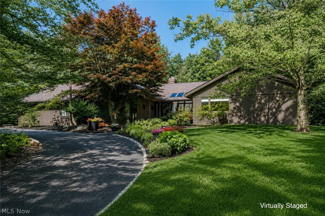 An unparalleled opportunity in Pepper Pike and set on a quiet cul-de-sac street, this expansive modern ranch offers refined living, striking architectural details, and exceptional privacy. An impressive entry framed by stunning double doors, welcoming you into a dramatic living room with soaring vaulted ceilings, gleaming hardwood floors, and walls of windows that bathe the space in natural light. A sleek two-sided fireplace and sliding doors seamlessly connect the indoors to the surrounding landscape. The beautifully renovated eat-in kitchen blends style and functionality, featuring granite countertops, a large center island, stainless steel appliances, tile backsplash, updated wood cabinetry, and a spacious dining area anchored by a charming brick fireplace. Just beyond, a sun-filled four-season room provides the perfect setting for morning coffee or a relaxing evening retreat. A formal dining room offers an elegant space for entertaining, while the casual dining area creates a warm atmosphere for everyday gatherings. A first-floor laundry room, mudroom, and conveniently located guest powder room complete the main living spaces. Privately situated, the primary suite serves as a luxurious retreat with a spacious bedroom, dual walk-in closets, and a thoughtfully designed ensuite bath featuring a custom walk-in shower and double vanity. Additional bedrooms are positioned nearby and share a well-appointed full bath. Enhancing the home's appeal and value are numerous recent improvements, including fresh exterior paint, new front gutters, new skylights, refreshed landscaping, and additional updates throughout. Surrounded by lush gardens and mature plantings, the outdoor living spaces provide a tranquil backdrop for relaxing, entertaining, and enjoying spectacular sunset views 
from the deck or patio. This impeccably maintained residence offers a rare combination of sophistication, comfort, and true move-in-ready convenience. A true sanctuary.
