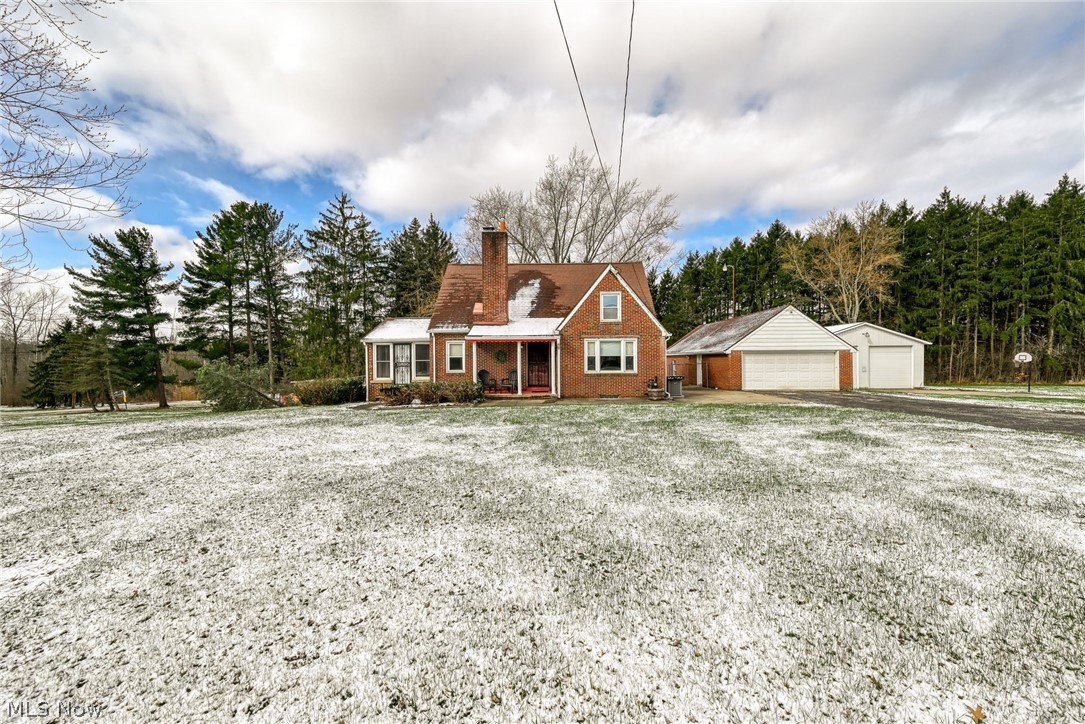 Welcome to this charming Cape Cod nestled on a 3 ACRE setting - offering the perfect blend of character, space, and modern updates!  Whether you are a hobbyist, car enthusiast or need extra storage, you'll appreciate the 4-car garage with separate garage doors with openers, and a 31x30 outbuilding. Step inside and fall in love with the warmth of beautiful hardwood floors, timeless built-ins, soft arched doorways and the unique charm you simply can't replicate. The home has been thoughtfully updated with vinyl windows, Kitchen and both bath remodels 2023,  all kitchen appliances 2023, washer and dryer 2023, basement flooring 2026, stylish window blinds throughout 2023, replaced chimney flue liner 2025, furnace and a/c 2023. This home is truly move in ready! Relax by the gas fireplace in the large living room or step into the all season sunroom ready for reading, a home office, or hobbies. The basement offers even more finished living space with a large laundry room and two separate finished rooms ready to use for whatever needs you have, whether it be workout room, another bedroom, den? The basement is walk-out. The back door and the basement door will bring you outside to a wonderful covered patio and fenced (chain link fencing replaced 2023) rear yard perfect for entertaining rain or shine. The home is located on a corner lot and lined with trees to the rear giving you privacy from neighbors. Selling as is.