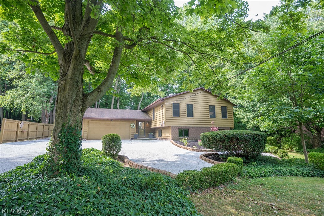 Tucked among the trees on nearly an acre in Concord Township, this cedar-sided retreat offers the perfect blend of rustic charm, timeless craftsmanship, and everyday comfort. Set deep on a wooded lot with fresh landscaping and multiple outdoor living spaces, 10676 Prouty Road feels like a private chalet getaway while remaining conveniently close to everything Lake County has to offer. The property spans 0.86 acres and features a wooded setting that creates a sense of peace and seclusion. Inside, warmth and character greet you at every turn. Thoughtfully designed with custom Danish cabinetry, quartz countertops, and two pantries, the kitchen combines beauty and function. An inviting foyer opens to more and expansive home with living space, where natural textures and architectural details create a cozy, chalet-inspired atmosphere. Designed for both entertaining and everyday living, the home offers three distinct gathering spaces, including a stunning great room with vaulted ceilings that serves as the heart of the home. Whether hosting friends or enjoying a quiet evening by the fire, each space offers its own unique character and connection to the surrounding landscape. With three full bathrooms and a half bath, the layout provides flexibility and comfort for family and guests alike. The home is retreat which invites the outdoors in, while the screened porch, three-season room, and expansive paver and concrete patios create countless opportunities to enjoy every season. Mature trees frame the backyard, offering room to explore, relax, and enjoy the beauty of nature. From morning coffee on the porch to evenings spent under the stars, this one-of-a-kind property captures the feeling of escaping to a mountain lodge without ever leaving Northeast Ohio. Rich in charm, filled with warmth, and surrounded by woods, 10676 Prouty Road is more than a home—it is a place to slow down, gather together, and create lasting memories.