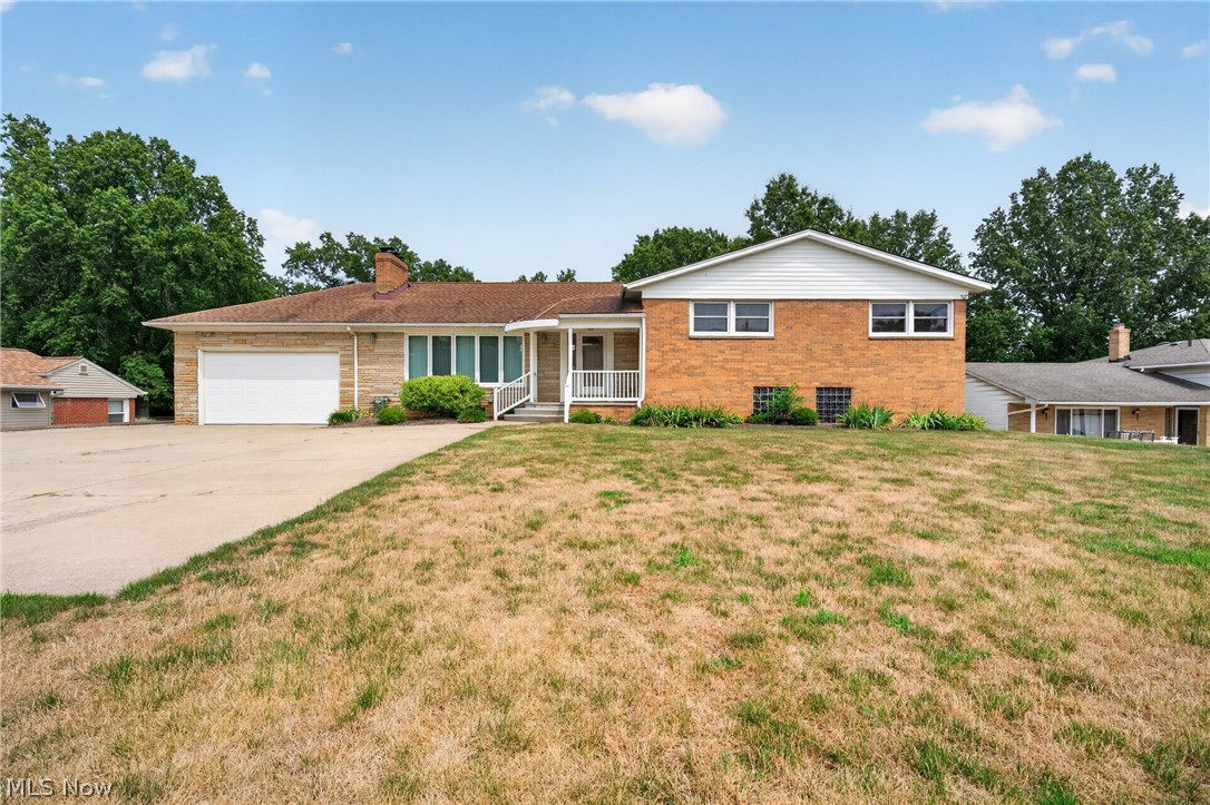 Welcome home to this exceptionally well-maintained split-level in desirable Seven Hills! Offering over 2,500 square feet of finished living space, this spacious home features 4 bedrooms, 2.5 baths, an attached 2-car garage, and a beautifully landscaped lot with mature trees.  The bright eat-in kitchen offers abundant oak cabinetry, generous counter space, stainless steel appliances, and plenty of room for everyday dining. Hardwood flooring flows through the bedrooms, while the inviting living room features a stunning floor-to-ceiling stone fireplace and oversized windows overlooking the backyard.  The finished lower level provides endless possibilities with an expansive recreation room, custom wet bar, half bath, and additional flex space perfect for entertaining, hobbies, or a home office.  Outside, enjoy a large backyard with two storage sheds, mature landscaping, and plenty of space to relax or entertain.  This home has been lovingly maintained for many years and offers an outstanding opportunity to personalize while enjoying solid construction and exceptional space. Seller is offering a one-year home warranty for additional peace of mind. Property is being sold as-is.  Conveniently located near shopping, restaurants, parks, highways, and all that Seven Hills has to offer.
