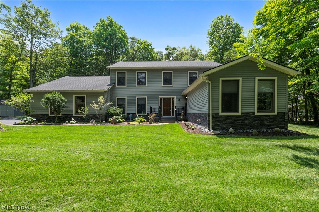 Rare Montville Twp., Multi-Generational Estate nestled on 2 park-like wooded acres! This beautifully updated Colonial offers unparalleled versatility. With 4 bedrooms, 3.5 baths, and a dedicated home office, this estate features a rare, fully independent main floor in-law suite. Complete with its own separate exterior entrance just off the front foyer, this private wing features a full kitchen, dining area, living space, laundry, and full bath—perfect for multi-generational living, a premier home business, or an incredible passive rental income opportunity. There is a newly updated luxury eat-in kitchen, which flows into the vaulted living room. Just off the kitchen is the formal dining room, or step into the spectacular, sun-drenched sunroom. Enveloped by windows and soaring skylights, the sunroom serves as your private oasis, stepping out onto a massive composite deck with a hot tub. Upstairs, the second level hosts the sleeping quarters, anchored by a magnificent Owner’s Suite featuring soaring vaulted ceilings. The private ensuite bath is a luxury retreat, boasting modern dark square-plank luxury flooring, a double-bowl vanity, a deep soaking tub, and a sleek, glass-enclosed walk-in shower. Two additional generously sized bedrooms, a second full bath, and a bright, dedicated executive office (or optional 5th bedroom) complete the upper level.  The finished lower level adds even more versatility, featuring a newly carpeted family room that provides a cozy and inviting secondary living space. The remaining half of this level houses the home's primary laundry room alongside a spacious, unfinished utility room complete with a recently updated, energy-efficient HVAC system. Outside you have the 2-car garage, breathtaking 2-acre private backyard, a large utility shed for extra storage, and a beautifully established garden bed ready for your green thumb. Newer roof and energy-efficient mechanicals.  Schedule your private tour today!