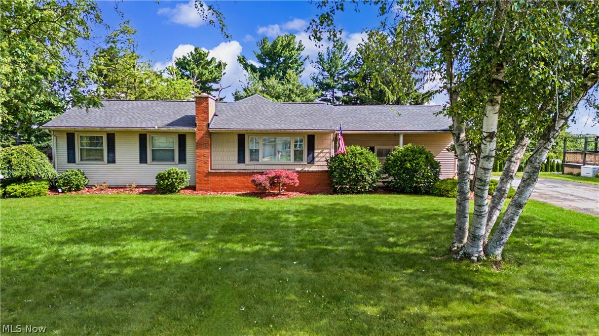 A home that feels warm and welcoming from the moment you arrive. This beautifully maintained ranch offers inviting living spaces highlighted by a stunning great room with a soaring tongue and groove ceiling and impressive stone fireplace, creating the perfect gathering place for family and friends. The maple kitchen provides abundant cabinetry and workspace, while updated flooring and neutral décor make the home move in ready. The renovated bathroom completed in 2025 adds modern style and convenience. Enjoy peaceful mornings on the covered front porch and relaxing evenings on the covered deck overlooking the fenced backyard. The finished lower level with custom bar offers additional space for entertaining, recreation, or game day gatherings. Recent updates include a new roof in 2026 and a new garage door opener system. Complete with a spacious attached garage, storage shed, and beautifully maintained yard, this property is ready to welcome its next owners home.