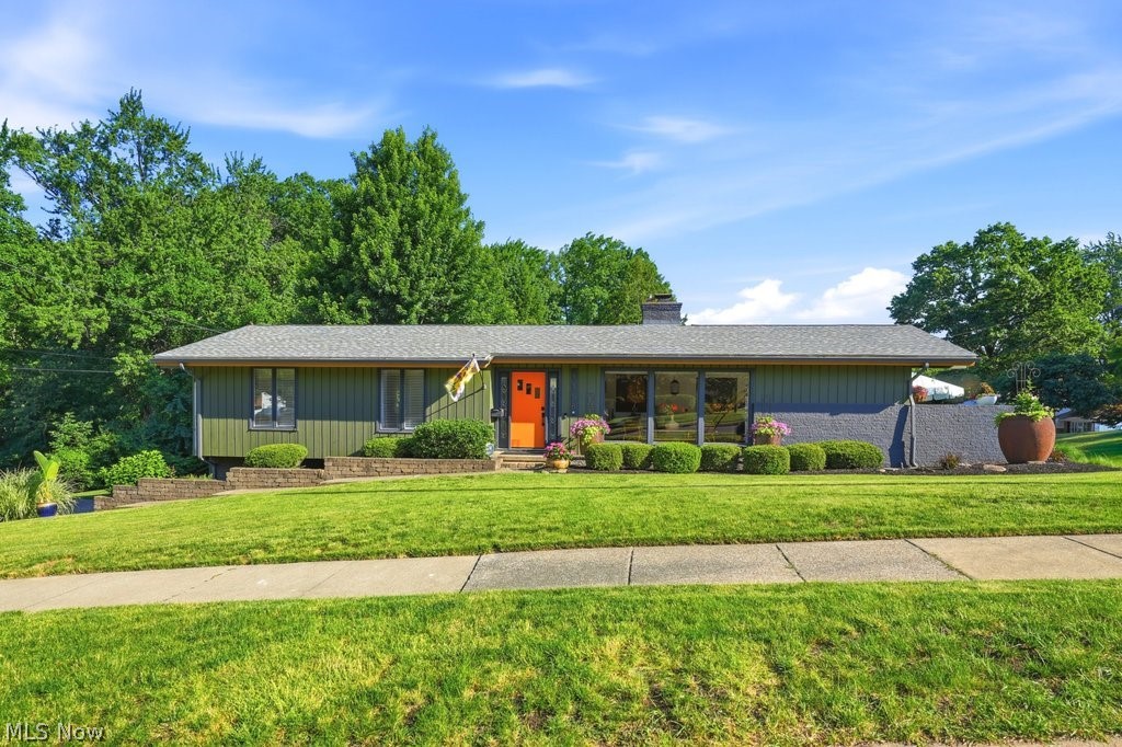 Mid-Century Modern Perfection in West Akron! Step inside this impeccable raised ranch, where timeless mid-century modern design meets updated convenience. From the moment you enter, soaring vaulted ceilings and dramatic walls of glass creates a light-filled, inviting atmosphere.  The updated kitchen showcases sleek modern finishes and hardwood flooring, flowing seamlessly into the main living spaces—ideal for both everyday living and entertaining. The versatile dining room, highlighted by a fireplace and expansive sliding doors, easily transforms into a warm and inviting family room, with direct access to outdoor living space enhanced by lush landscaping and stylish accents. The living room is equally impressive, featuring a wall of picture windows and an additional set of expansive sliding doors that lead to a second private patio retreat, perfect for relaxing and enjoying your favorite beverage. This home offers three generous bedrooms, including a private primary suite with its own en-suite bath. Both bathrooms on the main level have been tastefully updated for comfort and style. A striking spiral staircase leads to the bright lower level, featuring an additional family room, a third full bath, laundry area, and abundant storage. From here, step directly into the seemingly oversized attached two-car garage, complete with built-in shelving and cabinetry.  All this set among beautifully landscaped grounds. A modern shed, designed to complement the home, adds both functionality and appeal. Situated in the sought-after West Akron area, this move-in-ready home is a rare find. Don’t miss your chance—homes like this don’t stay on the market long! Sale is contingent upon the seller securing a home of choice.