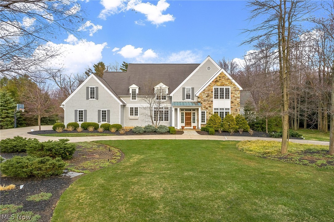 A circular driveway leads to this amazing stone and cedar home in a convenient and sought after location with hardwood floors throughout. The foyer welcomes you into this home with tasteful fixtures and plenty of open space. Leading between two pillars is the great room with a wall of built-ins, soaring windows and vaulted ceiling! The spacious eat-in kitchen with cherry cabinets and granite counters has high end appliances and recessed lighting. Attached to the kitchen is the 1st floor laundry, a half bath, and the attached 3 car garage. The dining room has tasteful lighting and  wall of windows creating a bright space overlooking the front yard's hydrangeas. The bonus living room is a nice quiet place separated from the openness of the great room and leads to the 1st floor master bedroom. The master with vaulted ceilings, tall windows and fireplace leads to an incredible marble master bath with deep tub, walk in shower and double vanity sink. The 2nd floor features a private office a