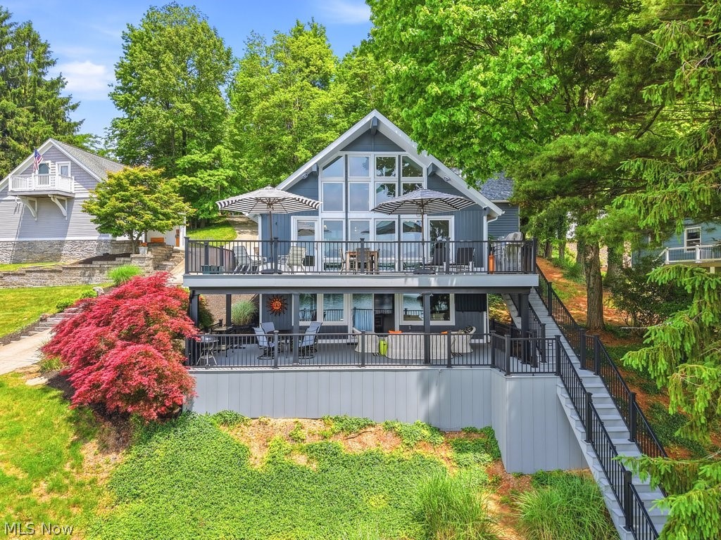 Experience luxury lake living in this beautifully renovated 3-bedroom, 2-bath A-frame lakefront home in the private, gated community of Lake Mohawk. Designed for comfort, entertaining, and enjoying the lake lifestyle, this exceptional home offers stunning lake views through a dramatic wall of windows that fills the interior with natural light.  The inviting open floor plan features engineered bamboo hardwood flooring, a soaring fireplace mantel, gas fireplace on the main level, and wood-burning fireplace in the lower level. The spacious kitchen is perfect for gathering, offering a large granite island with built-in storage, abundant cabinetry, and a gas stove. The home is wired for sound inside and out, creating the perfect atmosphere.  The rebuilt lower level offers additional living space, game area, laundry area, storage/utility room, and an updated full bath with a tiled walk-in shower. The main-level bath features double sinks and a glazed cast-iron tub/shower. Outdoor living shines with over 1,048 sq. ft. of composite decking, walkways, and stairs leading to the lake, a covered deck with Rain Escape system, and illuminated aluminum railings.  The waterfront is equally impressive with a highly finished seawall, premium all-aluminum Metal Craft docks.  A major highlight is the newly built (2024) 1,152 sq. ft. finished 3-car garage with loft. Extra deep and tall for boats and lake toys, it features a water hydrant for year-round use, backyard access, and loft area has potential conversion to guest quarters.  Recent updates include a new roof (2024), freshly painted exterior (2024), gutters and downspouts (2024), composite decks and railings (2024), Lennox furnace and A/C (2023), Rheem 50-gallon electric water heater, and additional dedicated parking added in 2025. Move right in and enjoy everything Lake Mohawk has to offer, including boating, fishing, swimming, golf, and year-round recreation from this exceptional waterfront retreat.