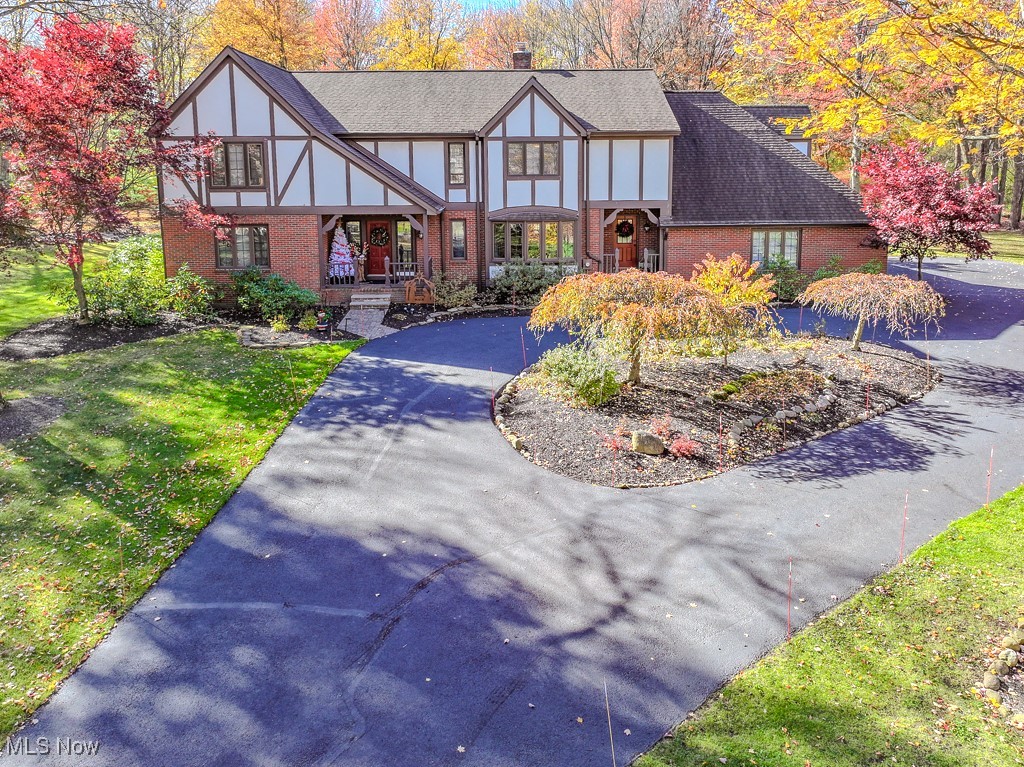Nestled on over 2.5 acres of a breathtaking, park-like setting, this beautifully updated Tudor home offers a private, tranquil escape in the heart of Gates Mills.  Situated at the end of a peaceful cul-de sac, it perfectly blends classic charm with modern luxury. The front entrance opens to an office with custom built-ins, and formal living and dining rooms. The updated cook's kitchen features a large Island, built- ins and a casual eating area.  A cozy family room with a gas fireplace flows seamlessly into the sunroom, where an abundance of natural light creates a bright & airy space.  Throughout the home, the millwork and moldings highlight the attention to detail and quality craftsmanship.  The upper level features four bedrooms, a versatile bonus room or fifth bedroom and three updated bathrooms, providing ample space for family and guests.  Escape to a completely updated primary suite where a vaulted ceiling, two walk-in closets, and a spa-like bath with soaking tub and custom shower create a serene, private sanctuary. The Lower level adds additional substantial living space with a large recreation room, a second gas fireplace, a convenient kitchen area, an exercise room, an updated full bath and plenty of storage.  Perfect for entertaining, the outdoor living space includes a newer composite deck, a large patio, an endless pool swim spa, a storage shed, and beautiful wooded views. The three car garage features a newer Polyaspartic floor, offering durability. This stunning home offers the best of both worlds: a luxurious and updated interior combined with the privacy and beauty of a natural retreat, all in the coveted village of Gates Mills.