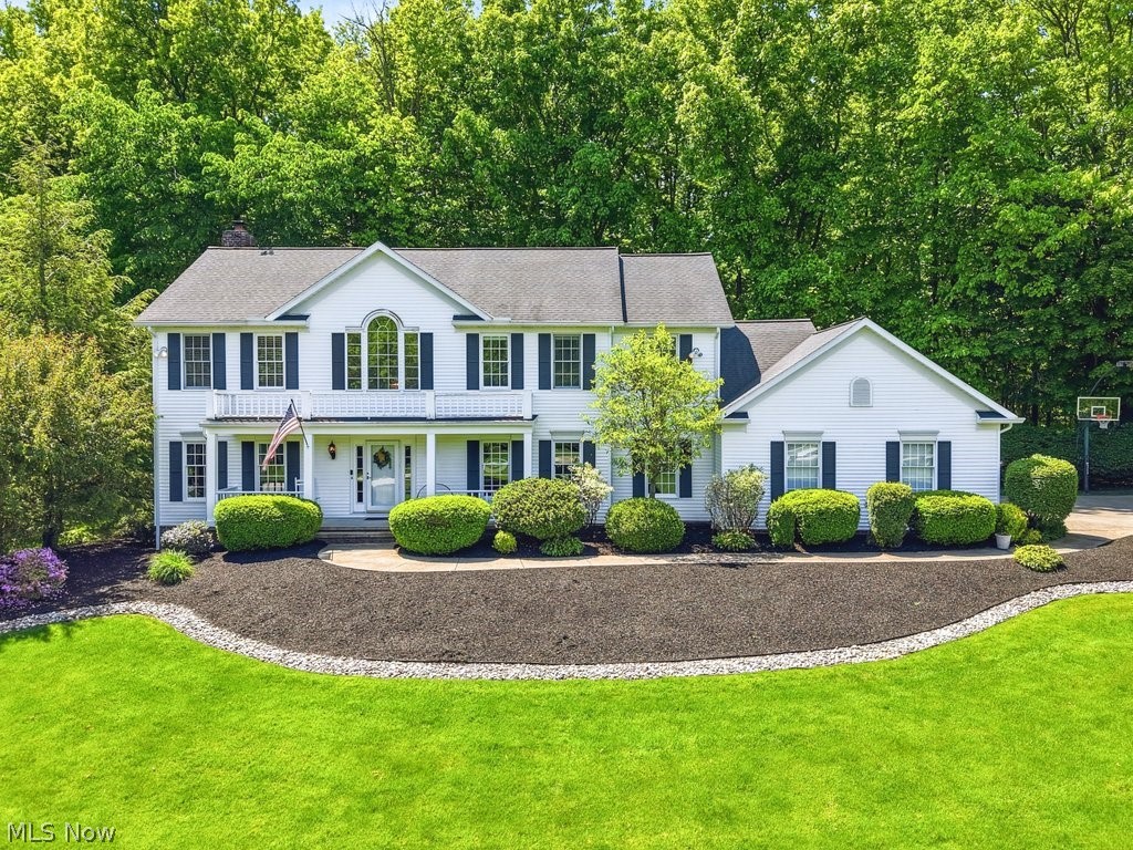 Nestled on a breathtaking 3+ acre homesite in the prestigious Hampton Ridge community, this exceptional colonial offers the perfect blend of privacy, elegance, and thoughtful updates. Surrounded by mature trees and beautifully manicured grounds, the property provides a secluded retreat while remaining conveniently close to Chardon amenities. A welcoming front porch introduces an impressive interior featuring rich hardwood flooring, extensive custom millwork, and thoughtfully designed living spaces. The handsome private library showcases floor-to-ceiling custom built-ins and French doors, while the formal dining room provides an elegant setting for entertaining. At the heart of the home, the beautifully updated chef's kitchen features granite countertops, newer appliances, abundant cabinetry, center island seating, and updated flooring, flowing seamlessly into the spacious family room with a fireplace and walls of windows framing serene wooded views. Upstairs, the luxurious owner's suite offers a private escape complete with a spa-inspired bath and walk-in closet. Throughout the years, the owners have made substantial investments to enhance both comfort and value, including a new roof, driveway, water softener, hot water tank, updated granite surfaces, and kitchen improvements. Outdoor living is equally impressive with a Trex deck expansion, dedicated hot tub level, custom granite-topped bar, and fire pit area designed for unforgettable gatherings and peaceful evenings surrounded by nature. Additional recent updates include new carpeting in the family room, dining room, and primary bedroom, along with a professionally serviced HVAC system. The finished lower level provides additional recreation and entertaining space, while the 3.5 car garage and expansive grounds complete this remarkable offering. Rarely does a property combine this level of privacy, updates, and timeless appeal within one of Chardon's most sought-after communities.