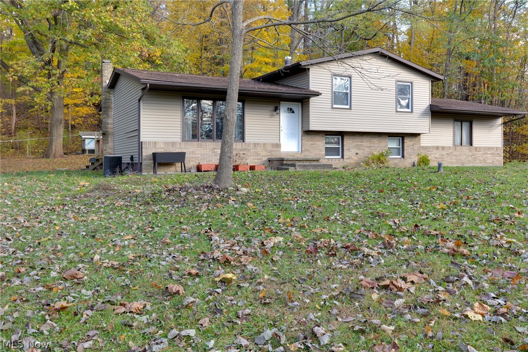 Escape to your own private retreat! This vinyl-sided 4-level split is tucked away at the end the road and situated on 6 scenic wooded acres. The open floor plan features beautiful wood-look plank flooring and a modern kitchen with a center island and seating, perfect for everyday living and entertaining. Offering 3 bedrooms, 2 full baths, convenient laundry, and a 2-car attached garage. The lower level includes a spacious family room with a charming brick fireplace and a dedicated office space. Enjoy peaceful views of the surrounding woods from the back deck. A rare opportunity to own a secluded property with privacy, space, and modern comfort. HOME WARRANTY INCLUDED!!