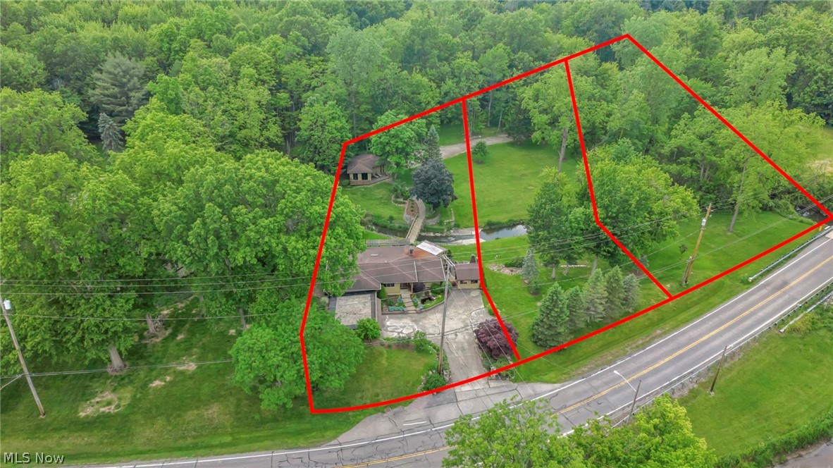 (Video Available) Truly once-in-a-lifetime opportunity! Imagine changing your lifestyle & living every day as though you're on vacation at one of the area's most prestigious & sought-after properties. Offering exceptional frontage, surrounded by Metroparks for remarkable privacy, one-of-a-kind estate features gently rolling, lightly wooded grounds, scenic flowing creek, plus beautifully updated bridge leading to an incredible entertainment hall & additional garage. Opportunities like this simply do not exist while still enjoying the convenience of city living. Meticulously remodeled/maintained w/uncompromising attention to detail, spectacular contemporary ranch is designed to immerse you in nature. Expansive walls of glass showcase breathtaking views of surrounding landscape & abundant wildlife while filling the home w/natural light. Open-concept floor plan offers an exciting blend of elegance and comfort, perfect for everyday living plus entertaining. 2+ car garage w/workshop provides excellent space for vehicles, hobbies, storage. Luxurious owner's suite is a private retreat featuring a sitting area, beautifully remodeled spa-inspired bath, dual closets. Additional bedroom showcases exciting loft design, while first-floor flex room currently serves as a home office but offers endless possibilities to fit your lifestyle. Step outside to an exceptional patio & entertaining/cooking area designed for unforgettable summer gatherings. Impressive detached outbuilding is ideal as a party room, rec center, hobby space, includes attached garage for equipment/storage, plus new low-maintenance deck overlooking the picturesque setting. Fish in your own creek, explore the rolling grounds, ride recreational vehicles on your private land, entertain family/friends, or simply relax and enjoy the unmatched peace/privacy. Extraordinary property offers a lifestyle unlike any other with convenient access to shopping, dining, highways. Must be experienced in person to truly appreciate.