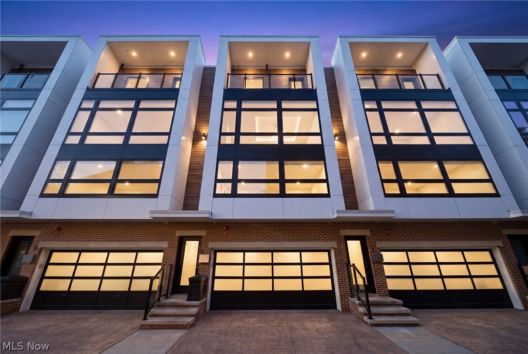 A location and townhome truly second to none! Tax abated through 2034! From the moment you step inside and ascend to the living area, you'll be captivated by a luxurious open-concept floor plan designed for everyday living and elevated entertaining. The sun-drenched living room anchors the space with a stunning stone fireplace and massive windows that bathe the room in natural light. The adjacent dining area features a built-in beverage fridge and custom cabinetry, while the well-appointed kitchen impresses with quartz countertops and premium stainless steel appliances. A convenient half bath is tucked on the stair landing for guests. Head up to the third level where brand new carpet sets the tone for the private quarters. An expansive primary suite is framed by dramatic floor-to-ceiling windows and features a generous walk-in closet and a spa-inspired ensuite bath complete with dual sinks and a beautifully tiled shower. A second full bath with a tiled tub/shower combo and quartz vanity serves the additional bedroom, which offers large windows and a walk-in closet. A dedicated laundry room with a front-loading washer/dryer combo completes this level. On the fourth level - also finished with brand new carpet - a spectacular room awaits, complete with a beverage fridge, a half bath, and access to the breezy rooftop deck. Your personal front-row seat to Cleveland's skyline, Lake Erie, summer fireworks, and the legendary Cleveland Air Show. Sunrises and sunsets have never looked so good. Back at ground level, a versatile bonus room opens to the enclosed backyard and two-car garage - a showstopper featuring a sleek polyaspartic-coated floor and impressive storage system. Step outside to the backyard, where brand new artificial turf offers a low-maintenance outdoor escape. All TVs convey! Move to an area that just keeps getting better every year (Irishtown Bend is next and new restaurants opening all the time!). The most walkable location you can dream up.
