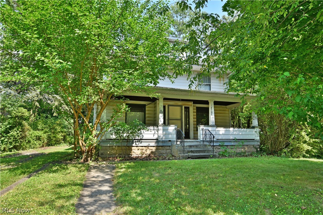Explore three floors of potential with this ready-to-renovate, three-bedroom Warren home with additional third floor attic space! The home sits in tree veiled privacy on a substantial lot, with an included driveway base and outbuilding foundation for a detached garage. A large, covered front patio spans the front of the home as you make your way inside the front door and through the foyer. Immediately, you’ll take notice of the thick stained woodwork that trims the baseboards and window casings of each room; a theme that continues throughout the home. Hardwood flooring below is easily revived as the expansive living room highlights a brick fireplace with built-in cabinets at the far side. The formal dining area offers its own casements as it traverses into the sizeable kitchen. Secure basement access is joined by separate rear entries to the home here. Upstairs, the winding landing delights with yet more built-in storage as the three bedrooms branch away with additional hardwood floors