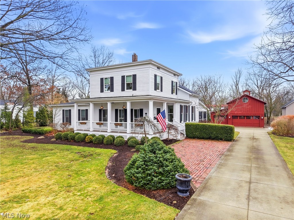 Set on an exceptional lot in Hudson’s historic village, this distinguished residence is widely regarded as one of the community’s most notable historic homes. Originally built circa 1854 by Henry Noble Day, a professor of Theology at Western Reserve College, the home carries a rich legacy deeply tied to Hudson’s early history. Today it presents a beautiful blend of period architecture and updated living spaces, soaring ceilings, charming wood floors, intricate millwork, and timeless décor throughout. The first-floor primary suite provides both comfort and privacy, complete with an adjoining den or study + an updated bath and direct access to a private exterior patio. Upstairs are three inviting bedrooms, including two connected by a shared private office + a beautifully remodeled second-floor bathroom. The home’s gracious foyer features built-in cabinetry + classic moldings. The kitchen is thoughtfully designed w white cabinetry, high-end appliances, and a center island with breakfast bar, opening seamlessly to a casual dining area with fireplace. A custom butler’s pantry + wet bar connect to a warm family room w coffered ceiling, built-ins, and expansive windows and doors that open to the patio and garden walkway. A spacious first-floor laundry + mudroom offers convenient access from the screened porch, with views of beautifully landscaped grounds. The outdoor setting is truly special, w brick patios, fire pit, privacy hedges, and a fountain. Two restored outbuildings further enhance the property. The three-car garage and barn includes a finished loft with full bath, custom Murphy bed, restored original barn flooring + HVAC. The second structure has also been fully restored and features a full bath, Murphy bed, and built-in shelving ideal for a home office, den, or guest retreat. Just steps from Hudson’s charming downtown amenities, this remarkable property represents a rare opportunity to own a truly distinctive historic home in a premier village setting.