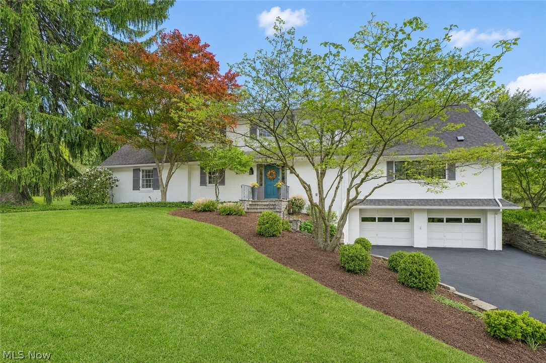 Set on a beautifully landscaped .88-acre cul-de-sac lot in the desirable Hills & Dales community, this exceptional 4-bedroom, 2.5-bath residence blends timeless character with elevated modern updates. A graceful stone staircase leads to the inviting front entry, where a spacious foyer with tile flooring, wainscoting, coat closet, and convenient half bath sets a polished tone. The living room offers a warm, sophisticated gathering space with Engineered Hardwood, a gas fireplace with mantel, bay windows, and built-in cabinetry and bookshelves. Double doors open to an impressive open-concept kitchen, dining, and sitting area designed for effortless everyday living and entertaining. Remodeled to the studs in 2022, the custom kitchen showcases a massive 5'x10' island with breakfast bar, Schlabach cabinetry, quartz countertops and backsplash, a 36" gas range with 6 burners and pot filler above, wine fridge, new Pella windows, and slider access to the backyard. This outdoor space shines with a concrete patio with room for dining and lounging, a built-in gas grill, and peaceful views of the surrounding landscape.
The first-floor primary wing provides a private retreat with a spacious bedroom, his-and-her closets, built-ins, and a bedroom. The updated full bath features double vessel sinks, tiled walk-in shower. A hallway linen closet and laundry chute. Upstairs, two comfortable bedrooms, a full bath with tub/shower combination, a large office space, a bonus room, and built-in hallway storage offer excellent flexibility. The partially finished lower level includes a large recreation room with additional storage space laundry area, and entry to the heated 2-car garage. Additional highlights include a brand new driveway in 2024 and access to Hills & Dales amenities including 24-hour neighborhood police, playground, tennis court, and town hall. A refined retreat in one of the area’s most established communities!