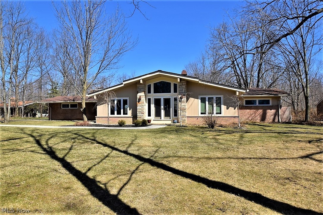 This stunning mid century ranch went through a total renovation in 2014 and has an incredible open floor plan with vaulted ceilings. The sun filled Foyer opens to an office and steps down to a spacious Living Room with cherry floors. Walls were removed to lead into the Dining Room and Kitchen with gorgeous maple flooring and a wall of windows overlooking the wooded backyard, deck and fire pit. At one end, the Kitchen has custom cherry cabinets, a large island w/ granite counters, stainless steel appliances, large pantry and extends into the open Dining Room with a sandstone wall and fireplace. The back hallway leads to three Bedrooms and two full Baths; both have custom cherry cabinets, granite counters, double sinks and the showers are wheelchair accessible with a no "lip" entry. Nothing has been overlooked and almost everything has been entirely replaced…all windows, front doors, all floors, all electric has been updated throughout, appliances, all plumbing, landscaping, septic, 2 fu