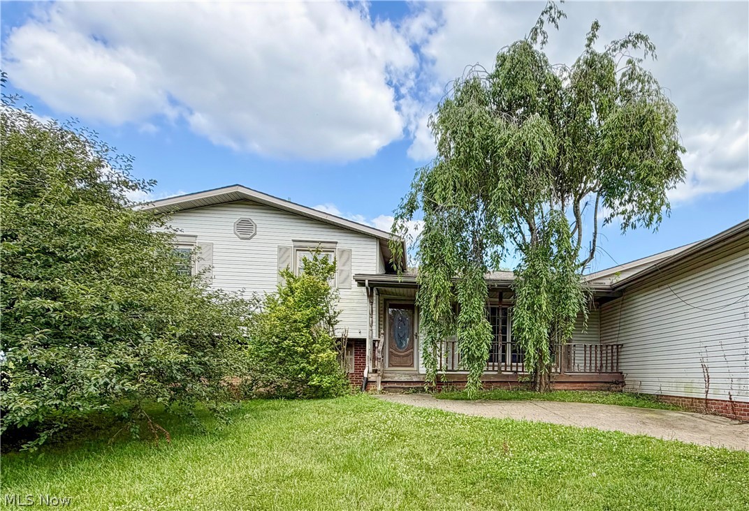 Packed with character and designed for entertaining! This unique split-level offers 2 bedrooms, 2 full baths, and an open layout full of custom rustic touches. The showstopping great room features soaring wood ceilings, a floor-to-ceiling stone fireplace, and a handcrafted bar, while the separate gathering room boasts exposed timber beams, a wood-burning stove, and a built-in projection screen for the ultimate movie or game-day experience. Outside, you'll find a detached garage, covered front porch, and spacious yard. With a little updating, this one-of-a-kind home offers an incredible opportunity to make it your own while enjoying features you simply won't find in the average home.