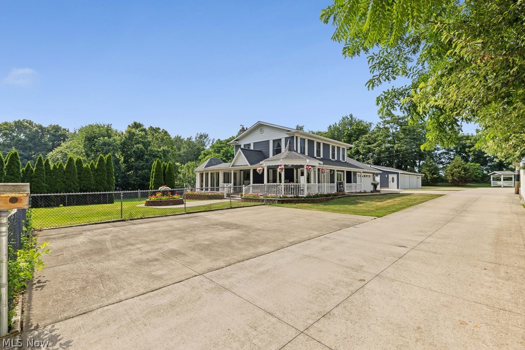 Welcome to your own private retreat near Springfield Lake! Tucked away at the end of a long private drive, this custom-built home offers over 2,000 square feet of living space with 5 bedrooms, 3 full baths, and an incredible 7-car garage, all surrounded by beautifully maintained landscaping. A wraparound covered porch and fenced front yard create a warm and inviting first impression.
The foyer welcomes you into a spacious living room featuring a large bay window and two ceiling fans, filling the space with natural light. The generously sized kitchen offers white cabinetry, white appliances, a tile backsplash, abundant counter space, and ample storage, making meal preparation and entertaining a breeze. Just off the kitchen, the dining room is highlighted by a charming chandelier. One of the home's standout features is the light-filled family room, complete with a cozy fireplace, ceiling fans, and walls of windows overlooking the picturesque surroundings. From here, you'll find a unique enclosed sitting room with a raised ceiling, surrounded by windows and sliding glass doors, creating the perfect space to relax with your morning coffee or unwind while enjoying the fresh air. The main level also includes a spacious first-floor bedroom and two full baths, one of which conveniently incorporates the laundry area. Upstairs, you'll find four generously sized bedrooms and an additional full bath, providing plenty of room. The full basement offers endless possibilities for recreation, a workshop, or future finished living space. Outside, the attached two-car garage is complemented by an impressive five-car detached garage, providing exceptional space for vehicles, hobbies, workshop projects, or storing your lake toys. If you've been searching for privacy, generous living space, and room for all your recreational interests just moments from Springfield Lake, this one-of-a-kind property is ready to welcome you home. Don't miss the opportunity to make this hidden gem your own!