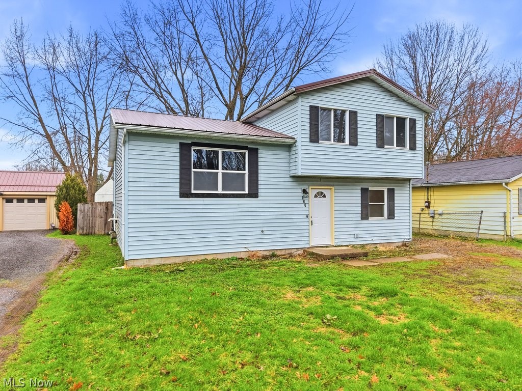 Completely updated and move-in ready, this charming 4-bedroom, 2-bath split-level home offers outstanding value with the feel of new construction. Recent renovations include wood-look laminate flooring, fresh neutral paint, updated doors, fixtures, ceiling fans, remodeled kitchen with new cabinetry and countertops, and two beautifully updated baths with new vanities, sinks, commodes, and fixtures. The main level features a bright living room, eat-in kitchen, and spacious sunroom perfect for relaxing or a home office. Upstairs are three bedrooms and a refreshed full bath, while the lower level offers a large fourth bedroom or rec room with walk-in closet, second full bath, laundry hookups, and access to the paver patio, backyard, and storage shed. Additional highlights include a crawl space for storage, off-street parking, metal roof (8-10 yrs), replacement windows, A/C (~8 yrs), furnace (2008), hot water tank, convenient access to Routes 5, 534 & the Ohio Turnpike, plus a 1-year America's Preferred Home Warranty.