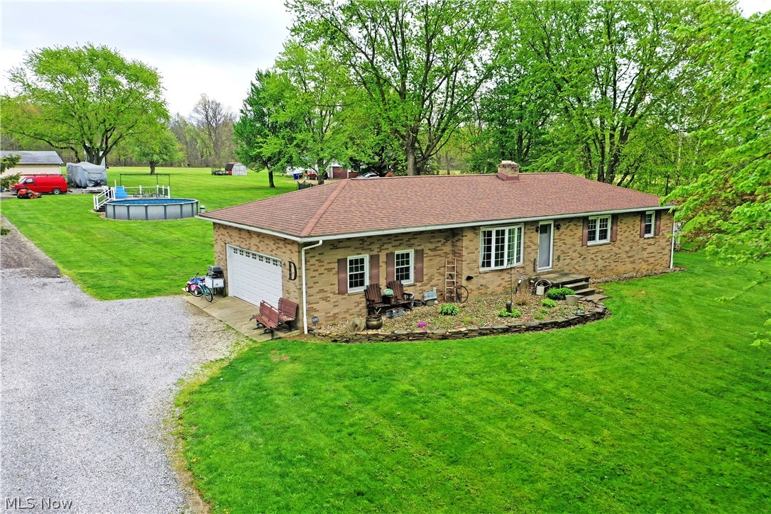 Turn your Farmhouse dreams into reality! This perfectly appointed Atwater residence doubles down with two floors of down home, rustic style that will be love at first sight within its advantageous, all-brick ranch construction. Set on an expansive lot and already configured with a large outbuilding garage and a livestock pen, this is turn-key country living at its finest with room to grow. Topping things off, a large above-ground pool is ready to be set up for summertime fun. Charm packed from the moment you enter the outstretched driveway, make your way past the two-car attached garage and front landscaping to gain access through the front door. Inside, a welcoming living room boasts soft carpets and tall windows that spill sunshine across the floors. Around the corner, the impressive, combined kitchen and dining space excites with an array of natural finished cabinets and a rolling island for easy prep and storage. Stainless appliances add to sparkle while a sliding barn door sits just past the dining room for additional pantry space. Down the main hall, three spacious bedrooms bring colorful and engaging surroundings to put you at rest. A must-see full bath is brightly lit with a daring, tiled shower.  Meanwhile at the basement level, a bonus rec room adjoins hidden storage and laundry, all while a second full bath delights alongside the finished lower family room. New furnace 2026, roof/windows/hot water tank 2013, waterproofed basement 2019, new pool liner this year, plus many more improvements done! Property line extends approximately 15-20 feet into the tree line. Nothing to do here but move in!!