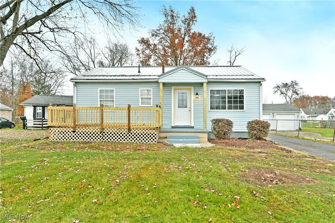 Revel in the bright, inviting charm of this eye-catching Warren ranch! Move-in ready and full of personality, this darling home blends comfort, style, and a desirable three-bedroom layout, all wrapped in a beautiful blue exterior that instantly stands out. Tucked within a well-established neighborhood, the welcoming front deck sets the tone, while the detached two-car garage adds character with its carriage-style windows. Both the home and garage feature durable steel roofing for long-lasting peace of mind. Out back, the nicely sized yard is partially fenced in for convenience and privacy, along with a handy storage shed tucked behind the garage, perfect for lawn tools and outdoor essentials. Inside, sunshine pours into the spacious living room where large lattice windows highlight the warm, wood-style floors. A sculpted pass-through opens into the generous kitchen, featuring elegant tilework, modern finishes, and a cozy dining nook accented by gray, wood-textured walls. Down the main hall, three comfortable bedrooms await, each offering soft carpeting and personal closet space. A charming full bathroom ties it all together with its stylish vanity and clean, updated feel. The partially finished basement extends your living potential with a great rec area, ample storage, and convenient laundry space. A perfect blend of charm, updates, and functionality, this home is ready to welcome its new owner. Updates include: all-new flooring in 2025, a brand-new kitchen with appliances in 2025, interior painting in 2025, a refreshed front deck in 2025, new entry doors in 2025, a brand-new furnace 2026, vinyl replacement windows, and so much more! Plus a one-year home warranty!