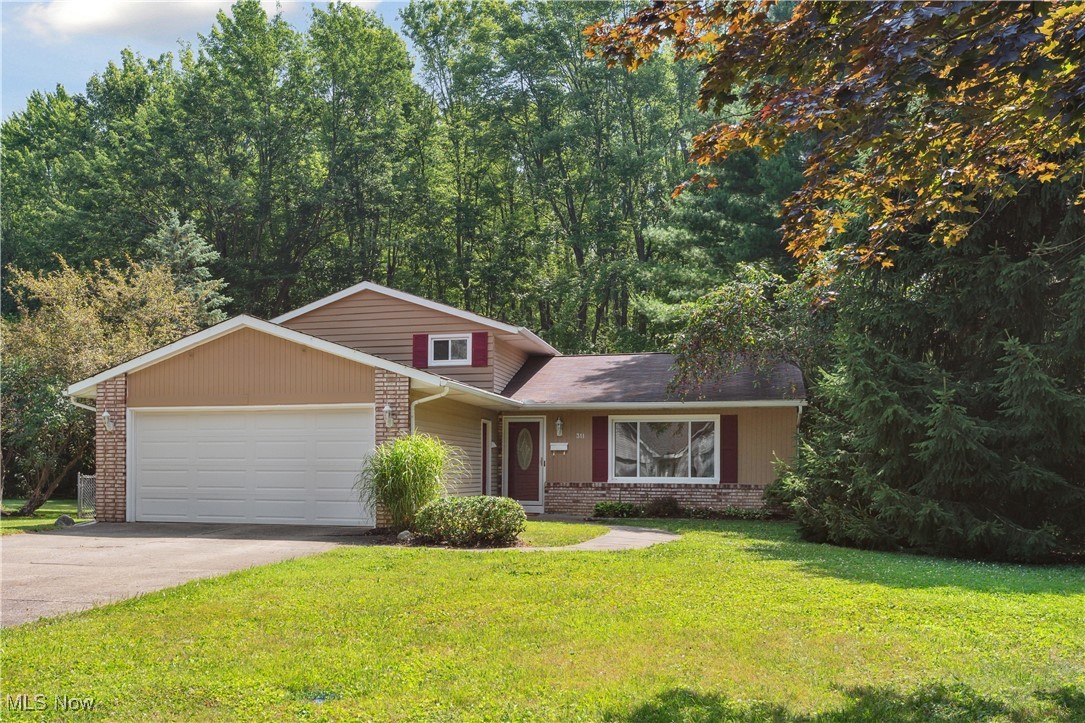 This charming split-level home, tucked away on a dead-end street, is located on a spacious lot offering beauty and privacy with trees and woods along the rear of the property. Conveniently located within walking and biking distance to Oberlin College and downtown, this neighborhood offers a unique path to enjoy the mile-long community trails to the north for your daily walks. An efficient layout begins with entering the main level into an open, bright, and large living room with beautiful views to the front and rear yards, an adjacent dining room and kitchen. The dining room opens to a generous deck, perfect for outdoor gatherings and outdoor dining. The kitchen includes all appliances, has plenty of countertops and cabinet spaces, and is large enough for a small dining nook if you prefer it for everyday meals. The upper-level features three comfortably sized bedrooms and a full bath. Downstairs, you will find a versatile family room with a fireplace to gather around, a hobby space, a utility and laundry room, and a full bath with a walk-in shower – offering room to spread for family and guests. Parking is easy with a front-facing two-car attached garage, a true bonus for Ohio weather! Other desirable features include fresh, neutral paint throughout, neutral new carpet on all carpeted areas, removed and repaired walls where the obsolete electric baseboards were present, central air, bonus tool shed, a fully fenced yard for pets or children, established perennial beds around the house, and a one -year home warranty for the Buyers! Move-in ready -  schedule your virtual or in-person tour today!