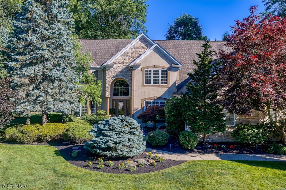 Welcome to 5808 Pinehurst Court! This custom 3 M Miozzi built home exudes luxury on a private, park-like ¾ acre cul-de-sac lot with exceptional outdoor living. With 4 bedrooms and 4.5 baths, this one owner home showcases impeccable craftsmanship, solid wood doors, designer finishes, and expansive Pella windows that flood the home with natural light and offer multiple backyard access points. The two-story slate-floored entry leads to an elegant formal dining room with a tiered ceiling and designer details, and a light-filled family room with two-story glass, a floor to ceiling stone fireplace, and a built-in entertainment center. The flexible layout features a first-floor primary suite with French doors, a large walk-in closet, and an en suite bath with Jacuzzi tub, plus a second floor en suite bedroom with French doors, expansive walk-in closet, and full bath. Two additional upstairs bedrooms share a Jack and Jill bath with double sinks. The gourmet kitchen includes premium appliances including a Viking range, KitchenAid refrigerator, and Bosch dishwasher, along with natural cherry cabinetry, granite countertops, multi-level islands, and a spacious eat-in nook. The extra-deep lower level offers expansive headroom, a full wet bar/kitchen, billiards area, private media room, expansive gym, full bath, generous storage, and warm layered lighting. Luxury continues outside with a welcoming front walk featuring a water feature and Zen patio, and a multi-tiered brick patio with winding paths. An outdoor kitchen with elevated stone bar, DCS grill, gas burners, and refrigerator enhances entertainment, while a pergola with flowering vines, seating around a wood-burning fireplace, and outdoor TV creates an inviting gathering space. Enjoy seasonal flowering beds, landscape lighting, and an upper-tier hot tub. Additional features include entire home sound system, reverse osmosis system, water softener, security, sprinkler system, storage building, and EV charging.