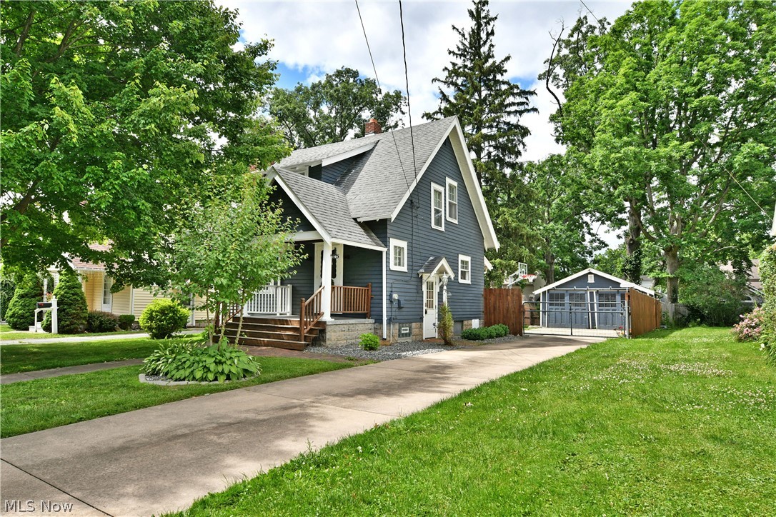 Presenting like a Pinterest-worthy showcase, this exciting Warren home is sure to impress! Artful and elegant from the inside out, the bold blue exterior and crisp white accents make this two-story beauty an instant standout. A covered front porch welcomes you home, while the concrete driveway leads to a powered security gate and a two-car detached garage. Blooming flowers line the way, adding vibrant color to the impressive rear patio and grassy side yard. Step inside to discover an inviting living room that takes full advantage of its large lattice-lined picture window, filling the space with natural light and highlighting the decorative stone fireplace. Around the corner, a breathtaking formal dining room combines elegant lighting with oversized windows to create an open, airy atmosphere. Dark accent walls pair beautifully with the ash-colored flooring below. Turning up the heat, the elaborate updated kitchen blends natural wood countertops, stainless-steel finishes, and sleek tile accents for a truly stunning presentation. The farmhouse sink serves as the perfect finishing touch. Upstairs, don't miss the must-see updated full bath, showcasing contemporary style and a uniquely designed soaking tub. A pair of impressively spacious bedrooms offers large closets and even a hidden llama surprise. Downstairs, the basement is ready to entertain with its striking bar area, while storage, laundry, and utility access are neatly tucked away behind a sliding barn door. This home also comes with a one-year home warranty!