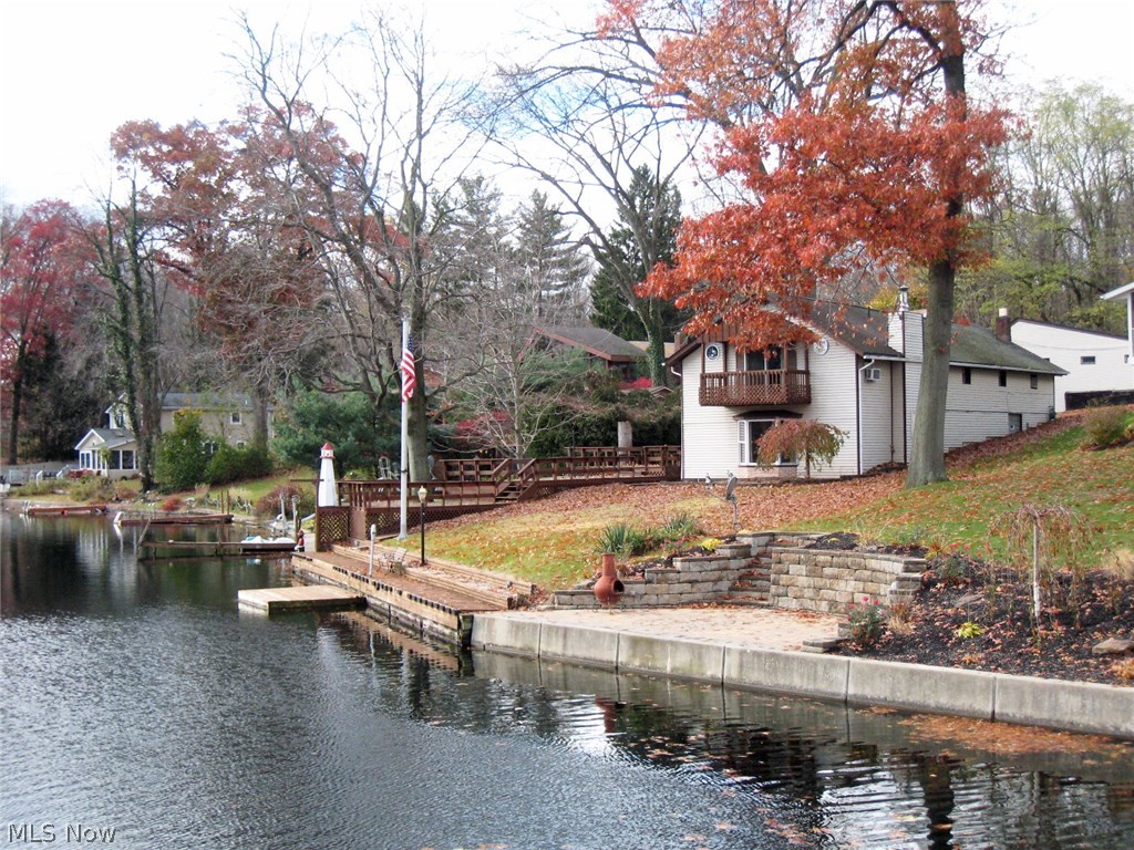 Tired of looking at tiny homes in Portage Lakes? This lake home has all the space you'll ever need and more with a four car garage and plenty of off street concrete parking. This home has over 2600 SF! The indoor and outdoor spaces are perfect for large groups with the huge 3-tier deck overlooking the water! Spacious rooms throughout the home.  Large living room features American gas burning stove and a large bay window with views of lake.  Large master bedroom 20x24 with private master bath, walk-in closet, and a private balcony overlooking the water.  Over 60' of lakefront with a planked walkway along the water which is 3'-4' deep, perfect for docking multiple boats without getting into weeds!   Don't miss out! Call today to schedule your showing!
