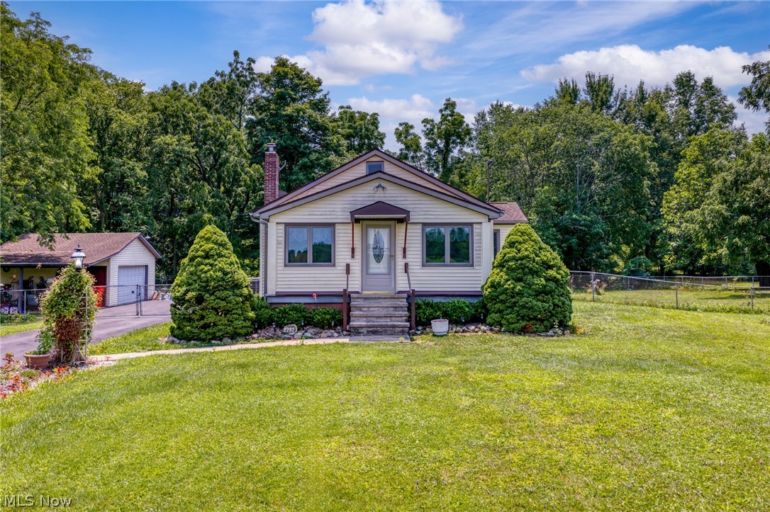 You don't want to miss out on this charming home nestled on a beautifully wooded 5-acre property! Offering the perfect blend of privacy and nature, this home features two bedrooms plus an office that can easily serve as a third bedroom to fit your needs. Plenty of room to expand as well. Relax year-round in the enclosed front porch with newer windows, or enjoy the fenced backyard with a full fence—perfect for children and pets. Venture beyond the fence, cross the bridge over the creek, and explore the remainder of your scenic property, where you'll find plenty of room to enjoy nature, recreation, or peaceful walks. The home also features a full unfinished basement, providing abundant storage. If you've been searching for a private country setting with beautiful outdoor surroundings, this is a property you won't want to miss.