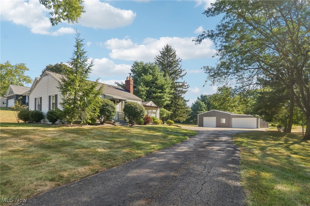 Discover your ideal retreat set in a serene country landscape, featuring modern amenities alongside an expansive outbuilding of over 1,500 square feet. Situated on nearly two acres, this beautifully maintained home showcases a harmonious blend of rustic charm and contemporary updates. Inside the home, the updated kitchen is a chef's dream, equipped with stainless steel appliances, an elegant tile backsplash, and upgraded cabinetry. The finished basement offers even more living space for a home office, rec room, or home gym. For outdoor enjoyment, relax in the inviting attached sunroom or spend an evening on the private stone patio, overlooking your spacious yard with mature apple, cherry, walnut, and chestnut trees. At night, enjoy stargazing while listening to the soothing sounds of the creek and warming up by the outdoor firepit. Let your imagination run wild in the outbuilding with enough space for up to 8 vehicles! It has gas heat, water, electricity, and garage doors on both sides. This versatile space is ideal for any kind of workshop!