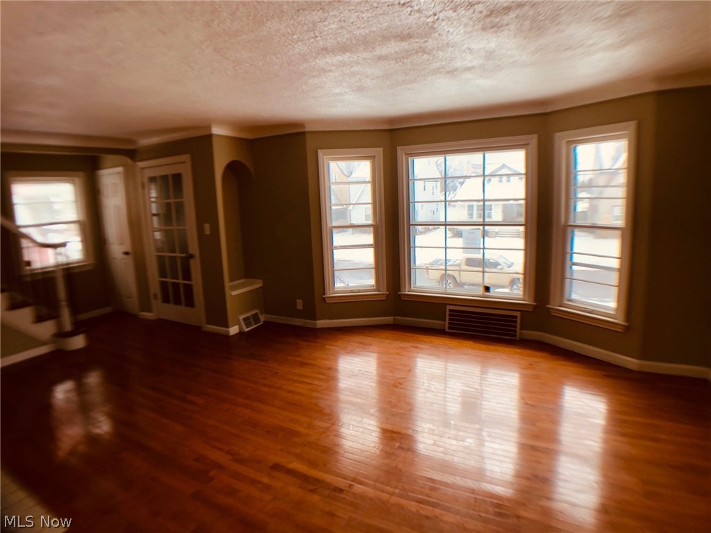 Move-in ready, spacious Colonial boasting over 1500 sq ft of above-grade living area, plus a partially finished basement recreation room with fireplace. Great for owner occupants or investors, this house would rent for about $1200/mo. Gorgeous hardwood floors throughout much of the home, including the huge living room with fireplace and bow window, formal dining room, and 3 upstairs bedrooms.  Kitchen is nicely updated with ceramic flooring, stainless dishwasher, newer fixtures.  Second floor bath features a deep jetted tub and separate shower.  Other features:  First floor den/office, 3rd floor walk up attic (great for storage), 2-car garage, ceiling fans, upgraded electrical, glass block windows.  Conveniently located near University Circle, Downtown Cleveland, Cleveland Clinic, shopping and schools.